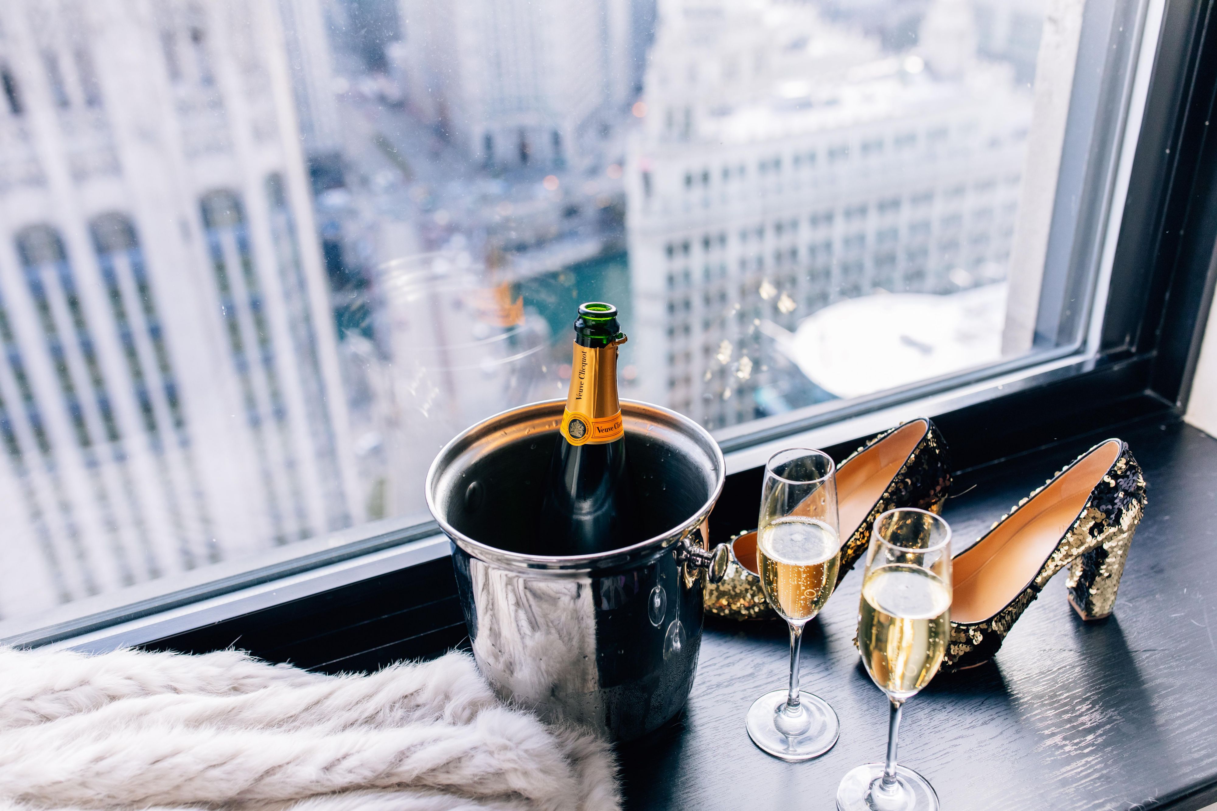 Bottle of champagne with heels next to guest room window