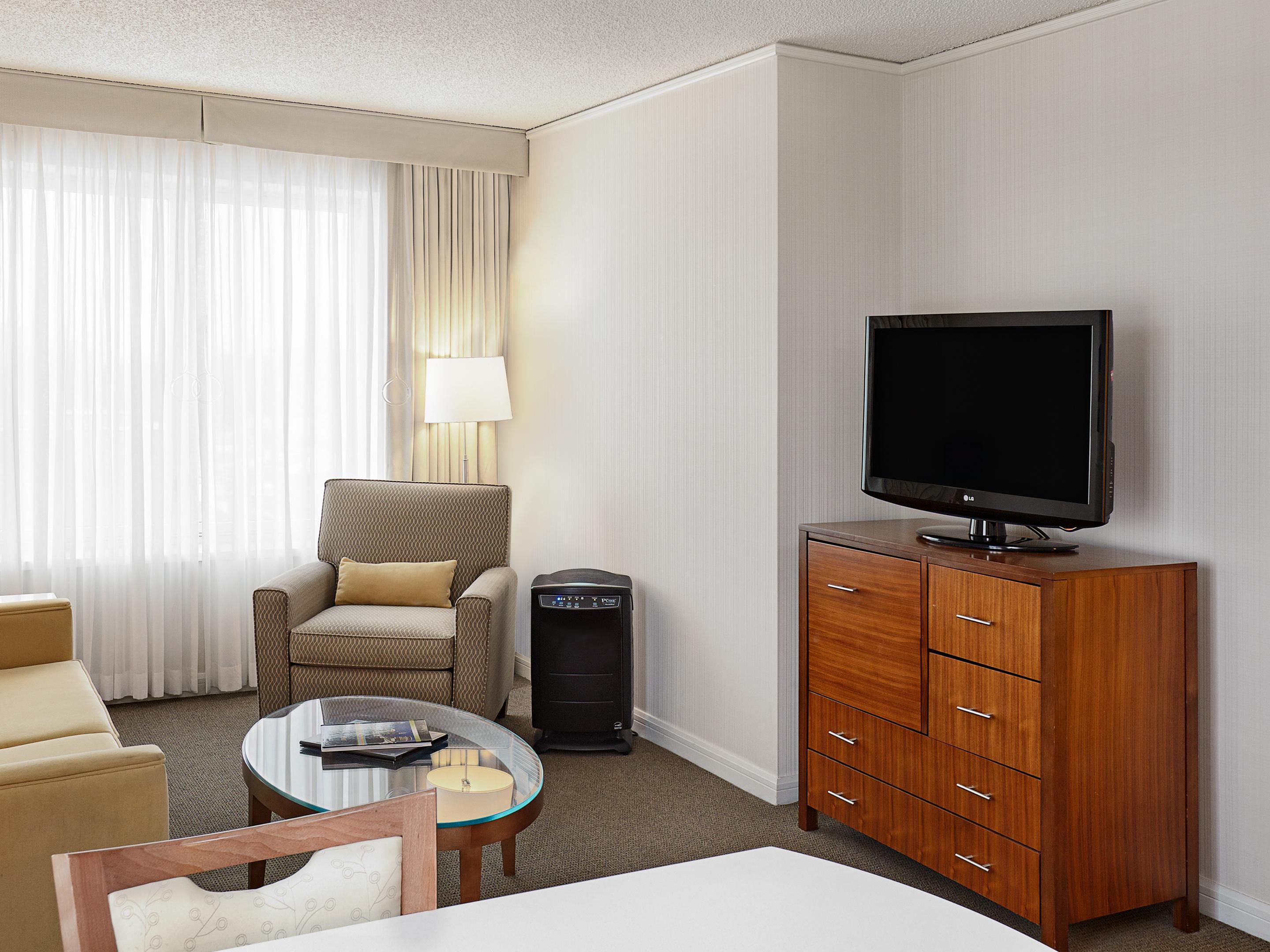 Spacious guest room with sleeper sofa, chair and dining table