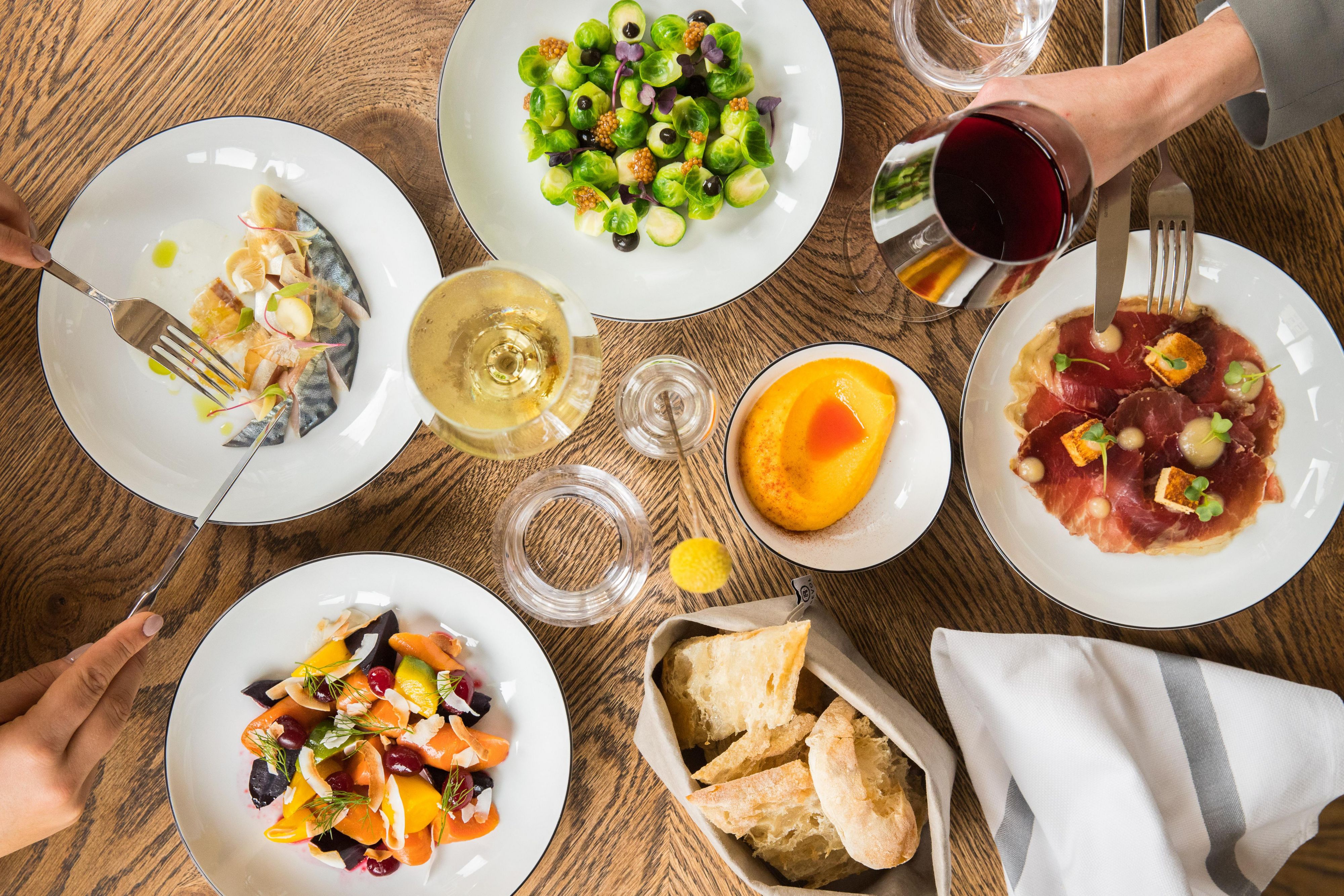 Assorted plated dishes, bread, and wine on a dining table
