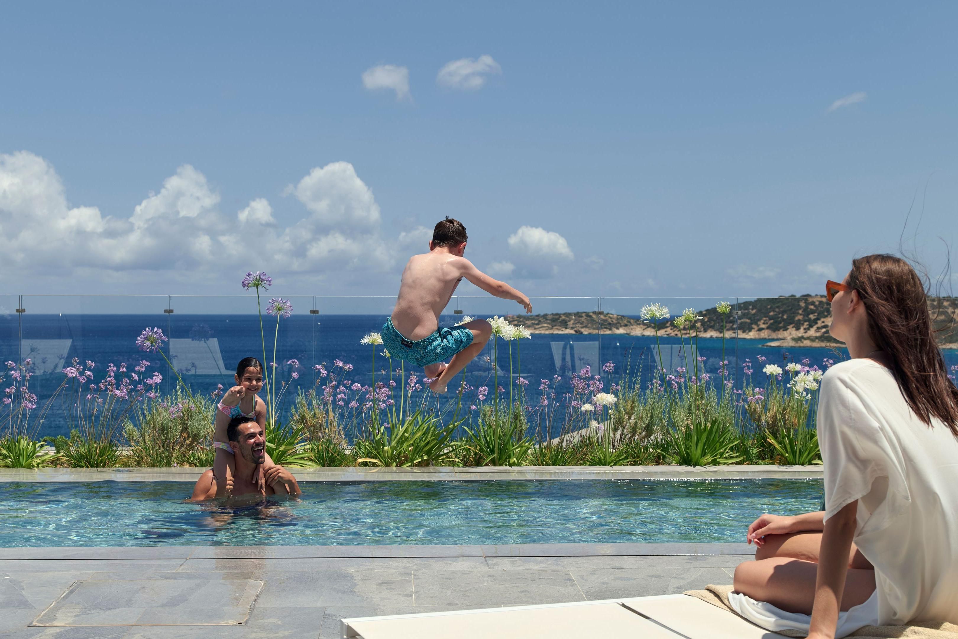 family playing in the pool in the sunshine