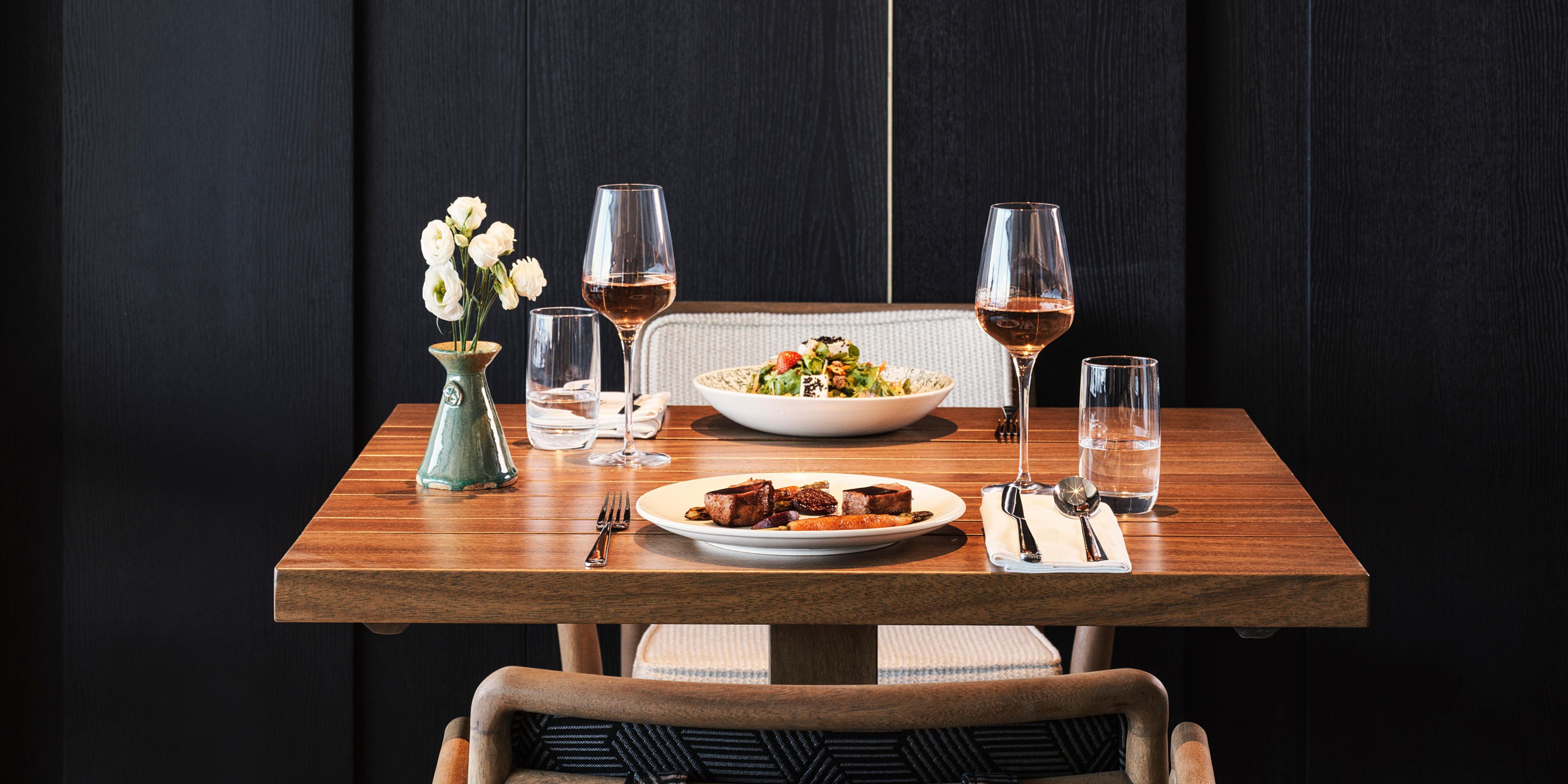 Dining table plated with various dishes and red wine