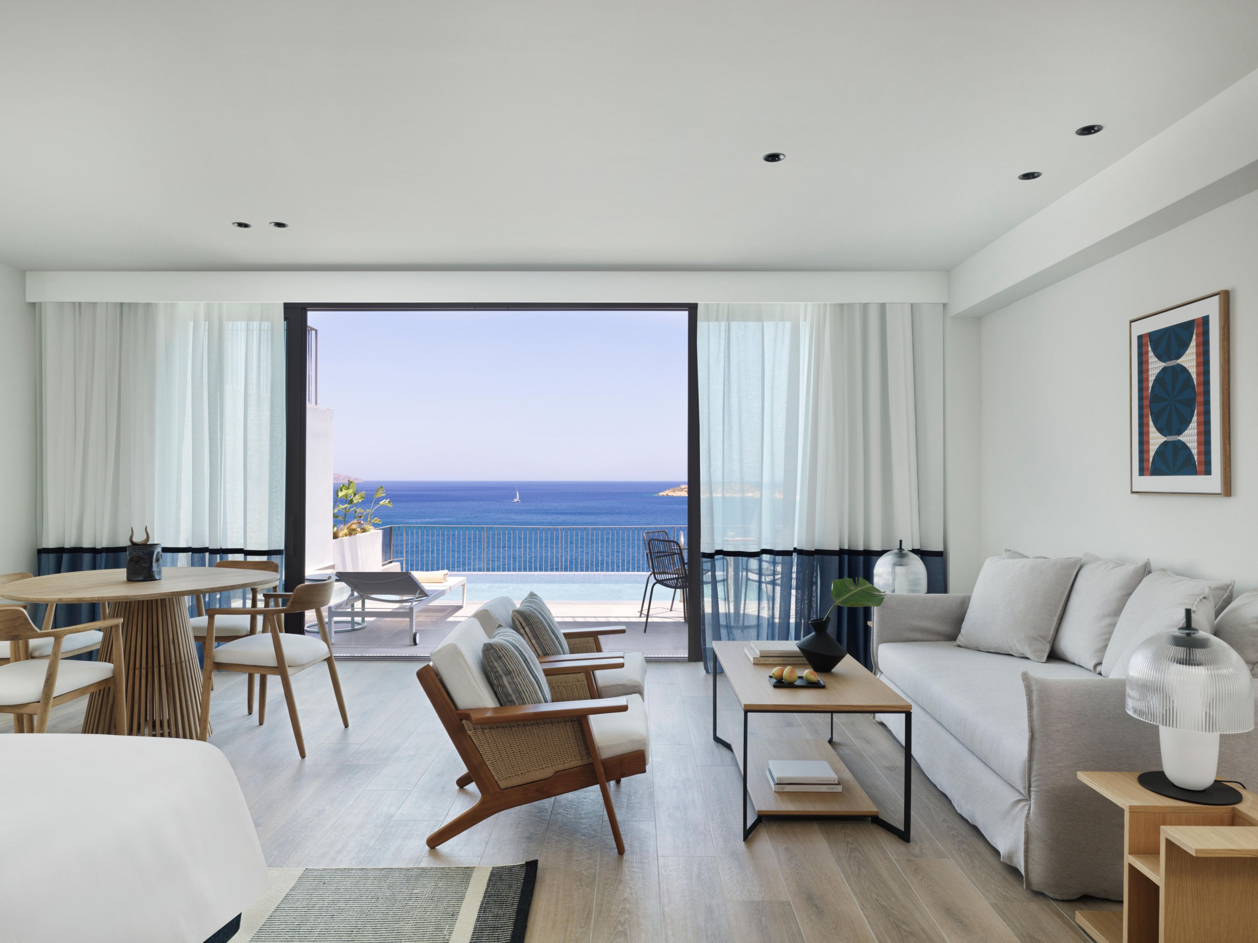 open plan large suite living area with dining table and chairs and ocean views