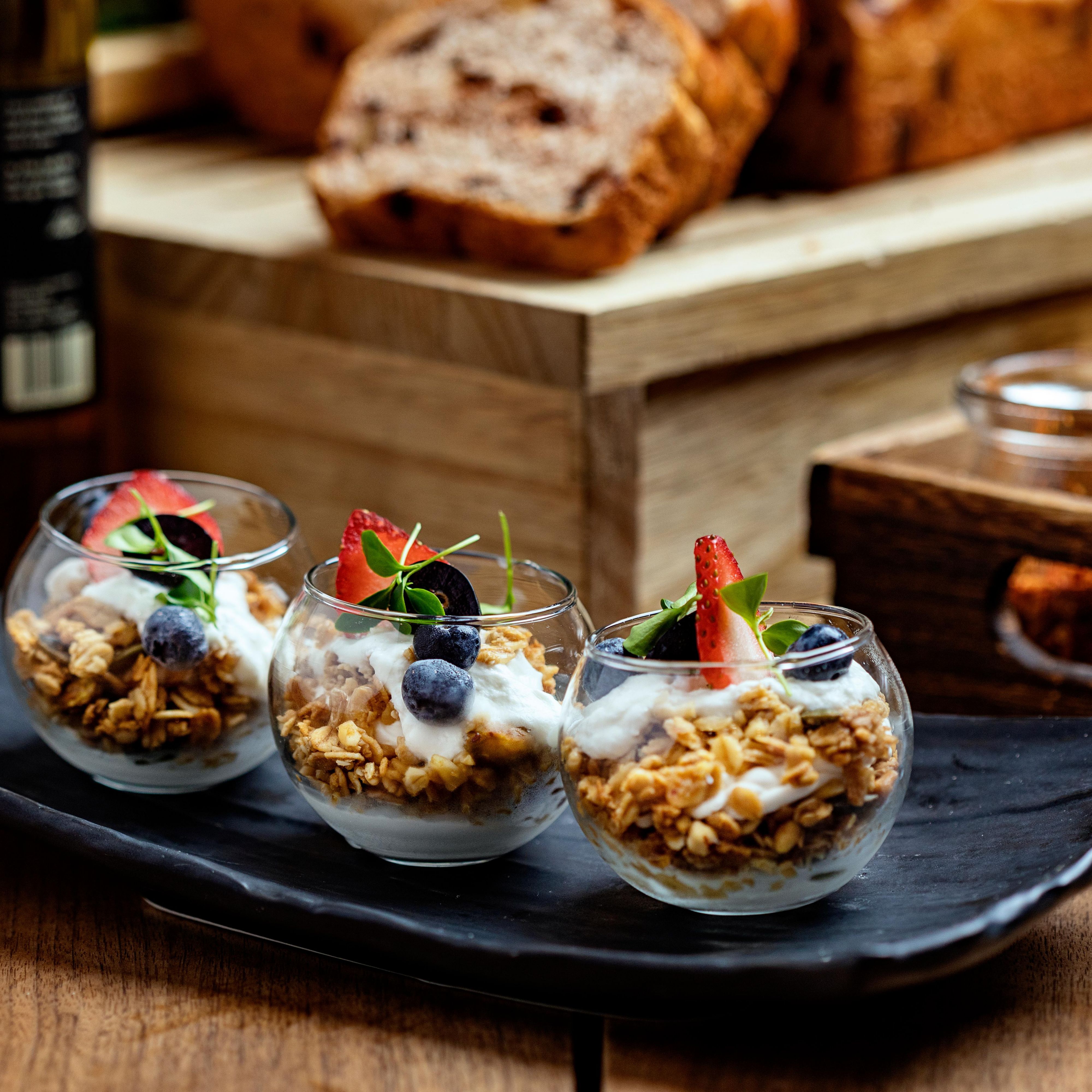 Three breakfast parfaits on a serving platter