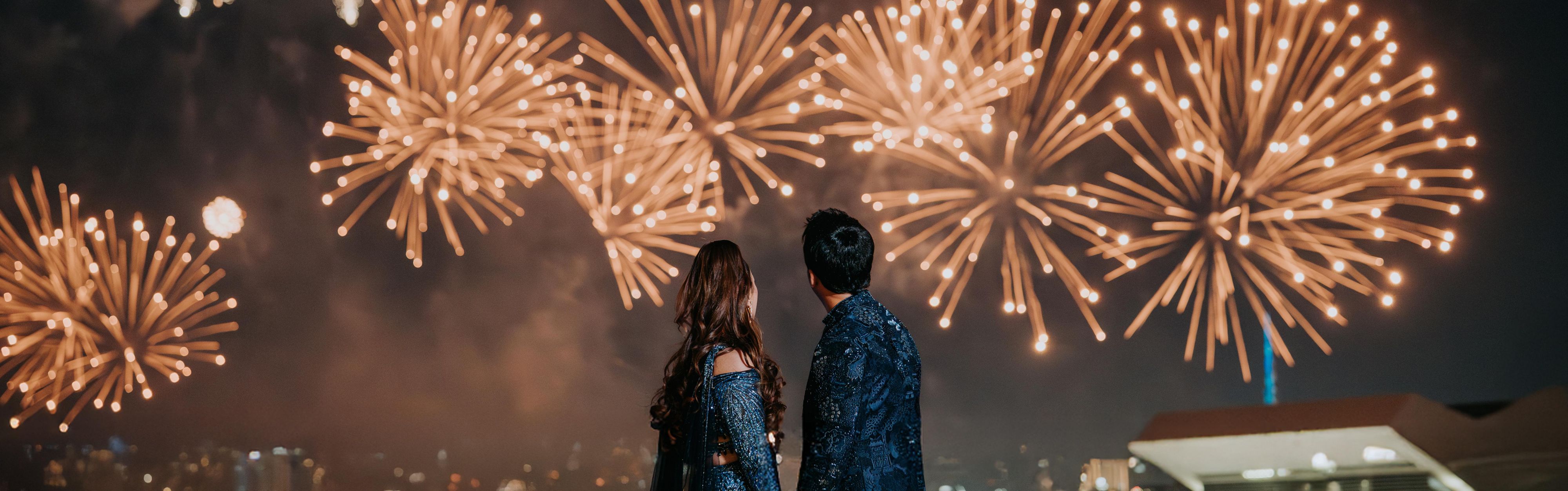 Bride and groom watching fireworks to celebrate. 