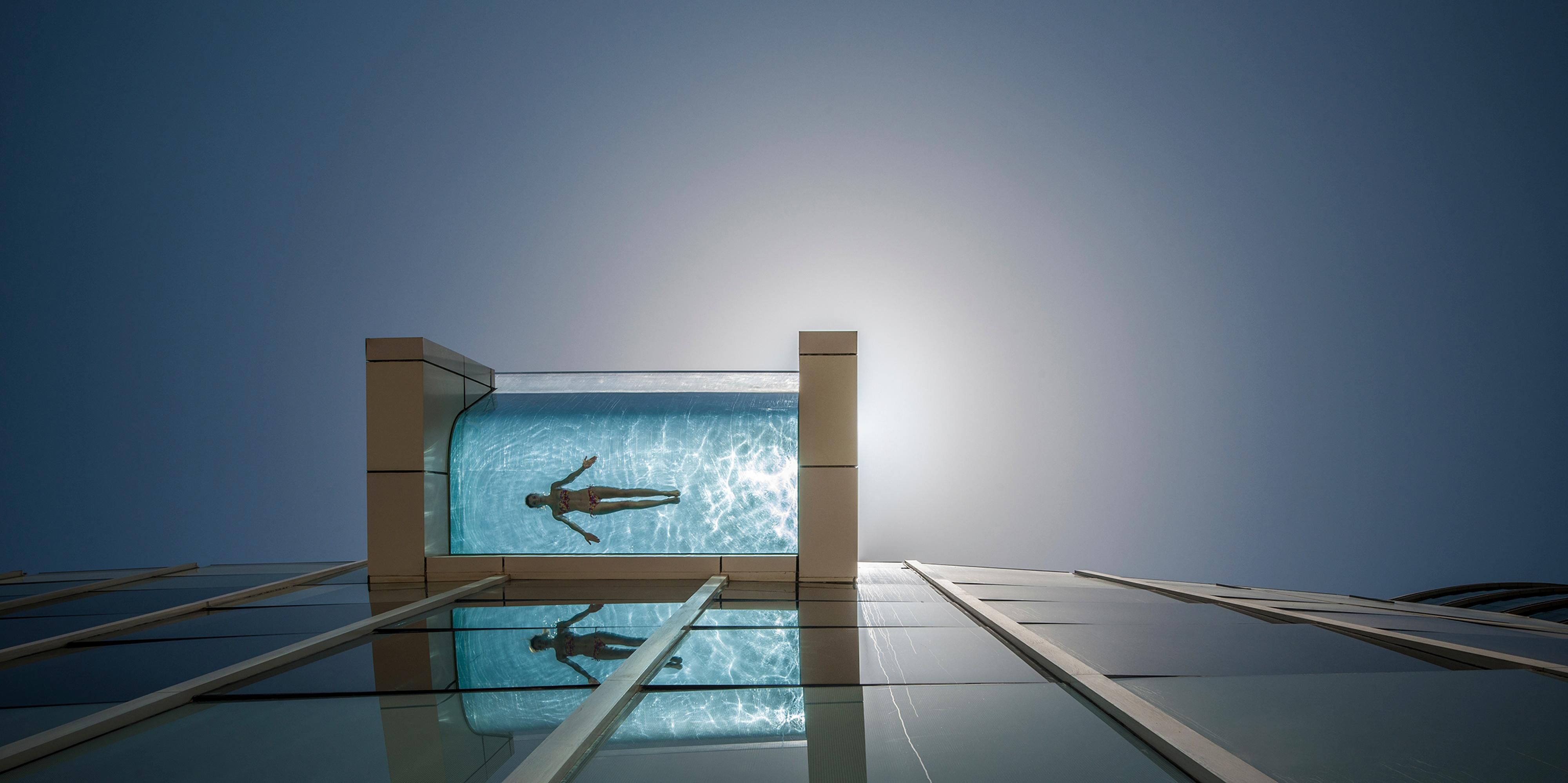 Glass pool with woman swimming