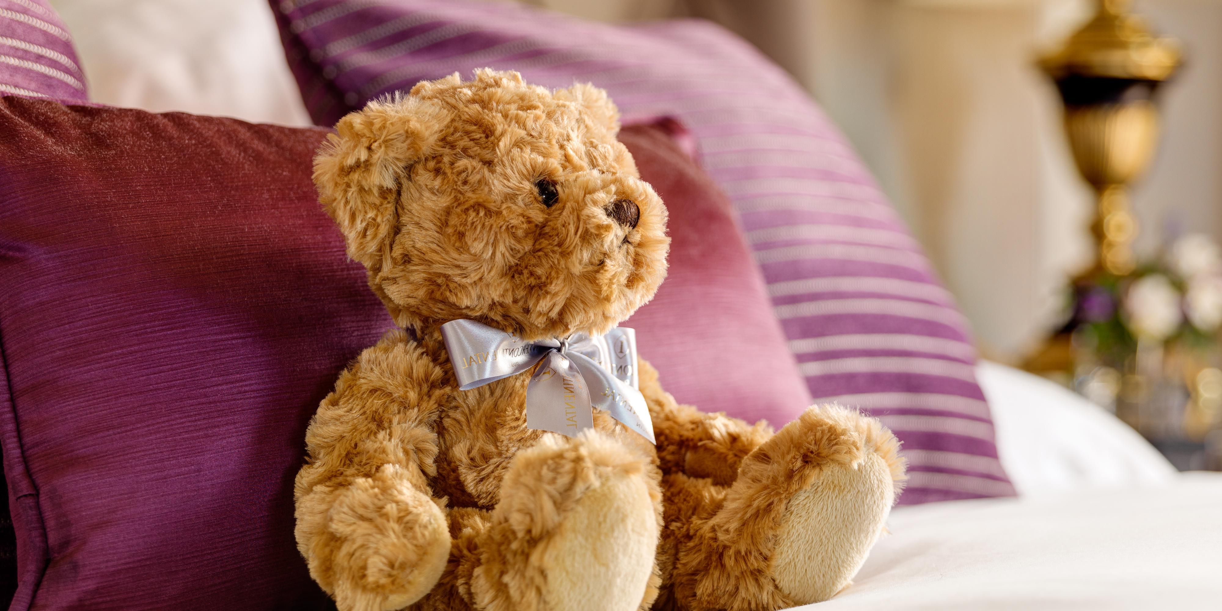 teddy bear sitting on hotel guest bed