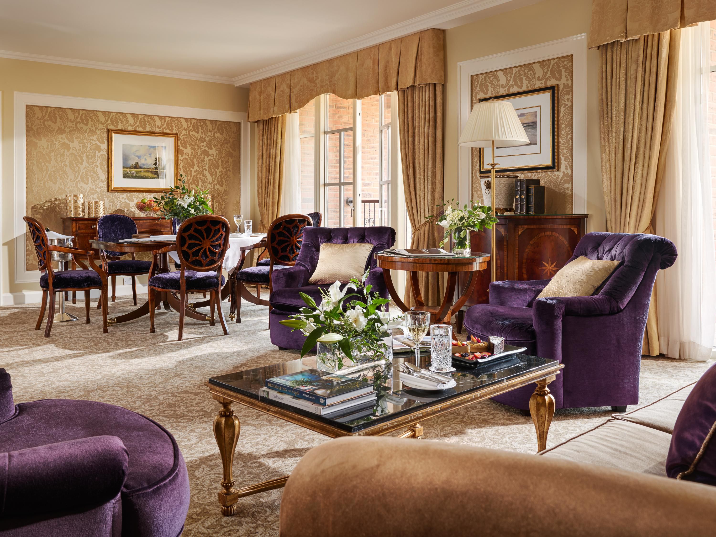 lady gregory suite with large living and dining area including large dining table and purple cosy armchairs