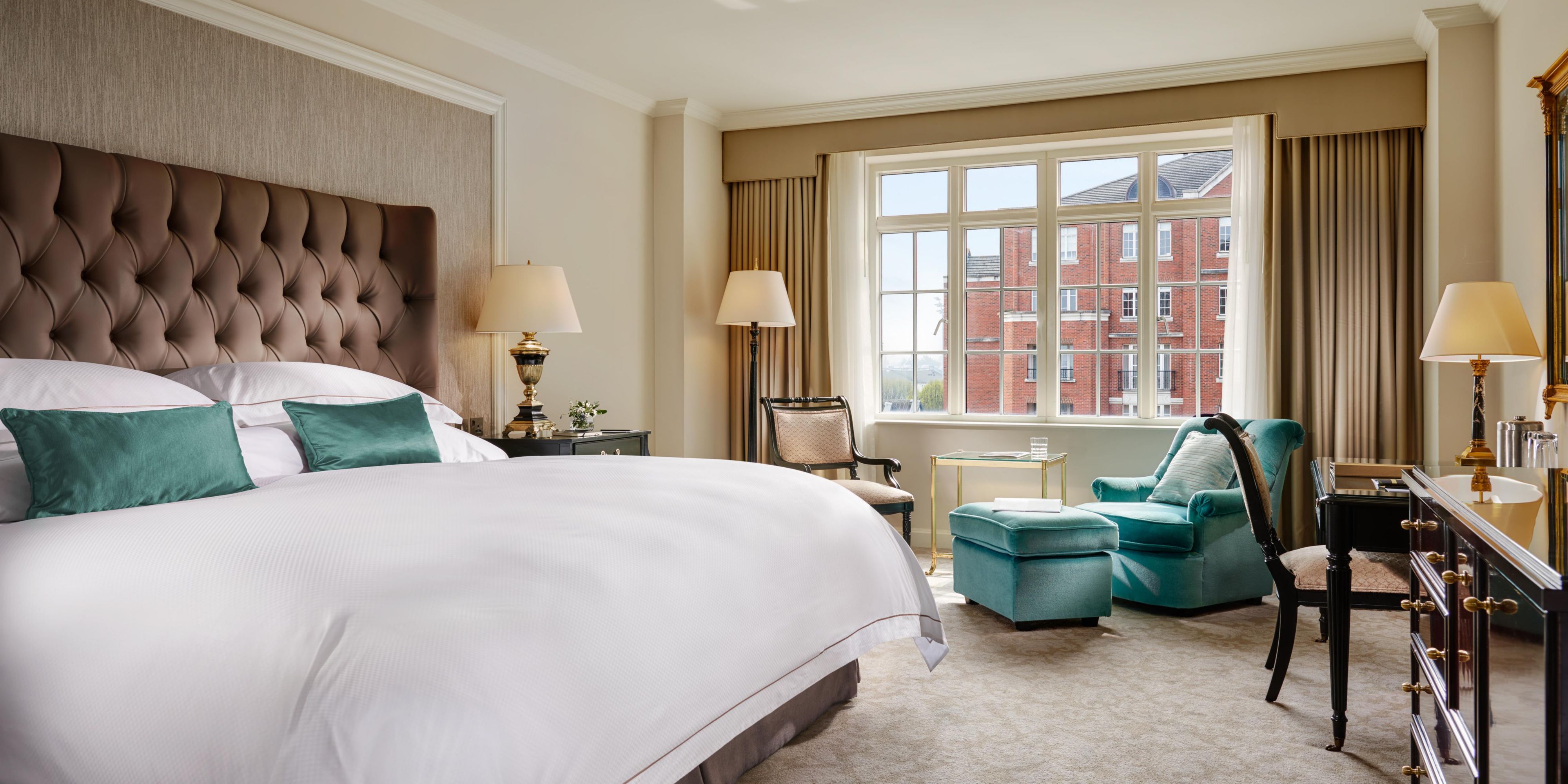 Cosy room featuring king sized bed, a large window, working desk and cosy chair
