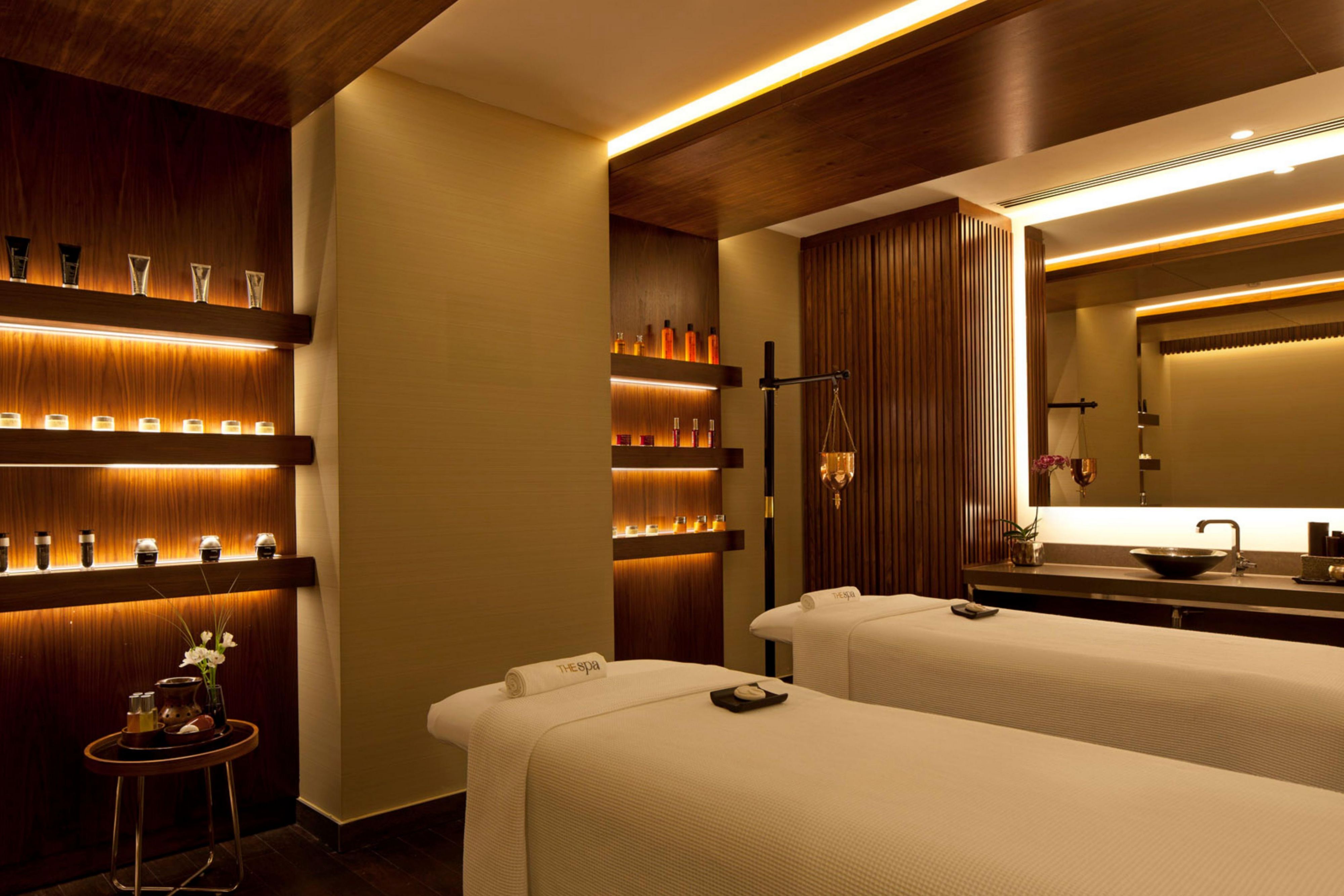 Sala de tratamientos de spa con camas de masaje e iluminación tenue