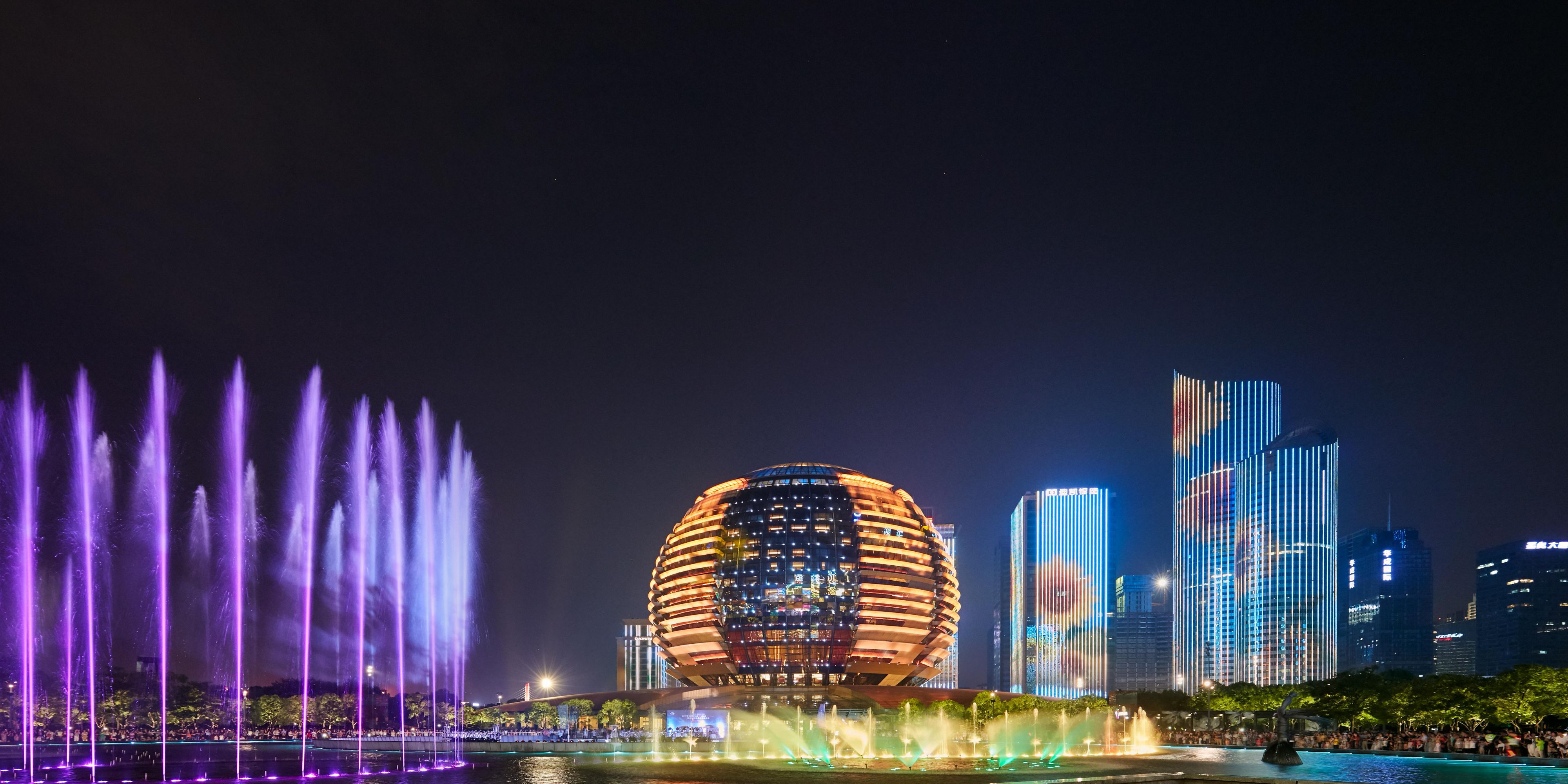 酒店以独特的金球造型坐落于潮水闻名天下的钱塘江畔，与对面月牙形的杭州大剧院形成“日月同辉”，这也是杭州新十景之一。两者中间是音乐喷泉，每当夜幕降临，客人不仅可观赏华丽的音乐喷泉，也能欣赏到著名的钱江新城灯光秀。钱江新城灯光秀为杭城著名景点之一，周边的建筑外观会在固定晚间时分展示一场以“城、水、光、影”为主题的灯光秀，展示“ 中国气派、江南韵味、杭州元素、新城特色”。