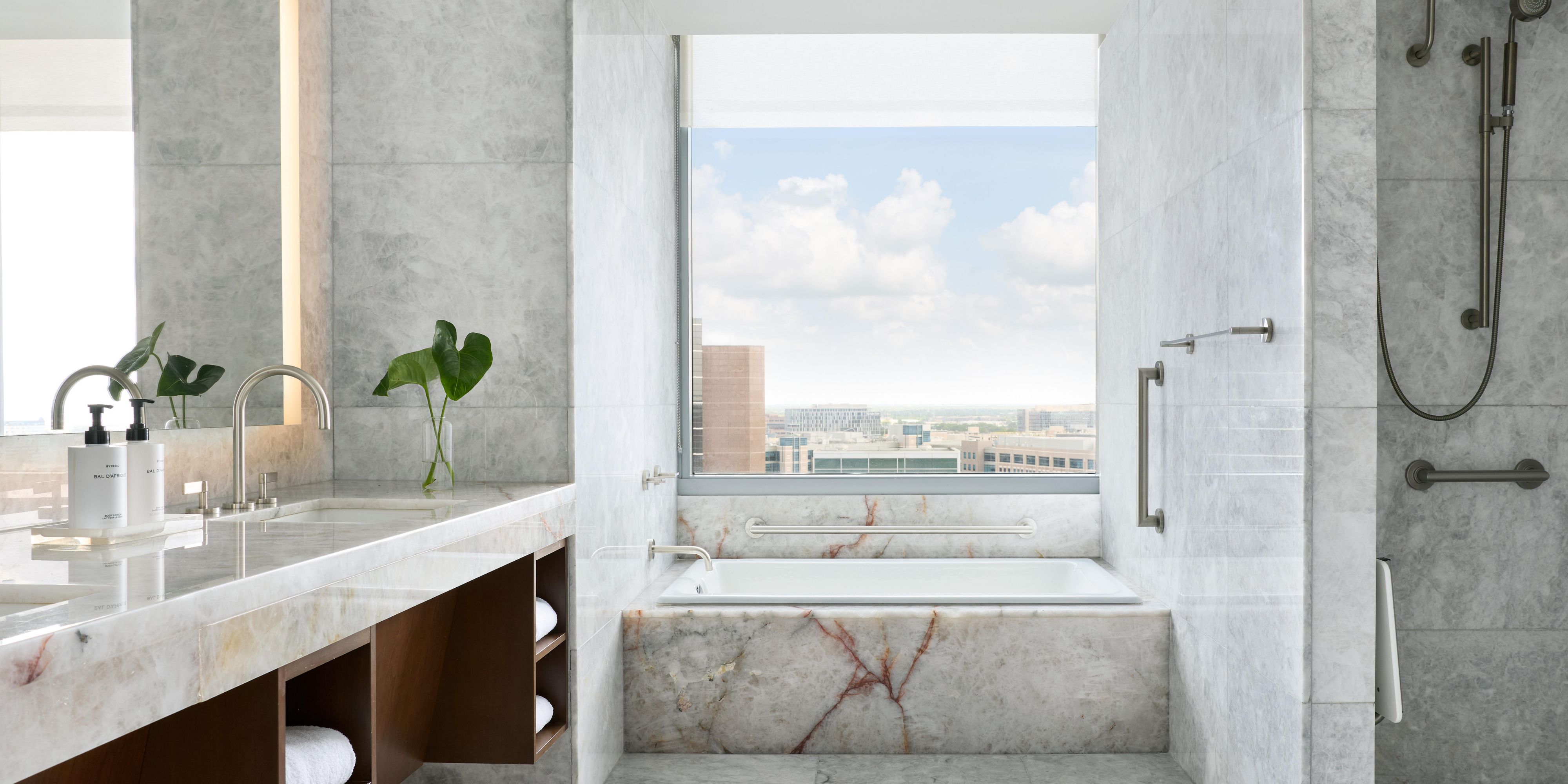 Marble bathroom with soaking tub and city view window. 