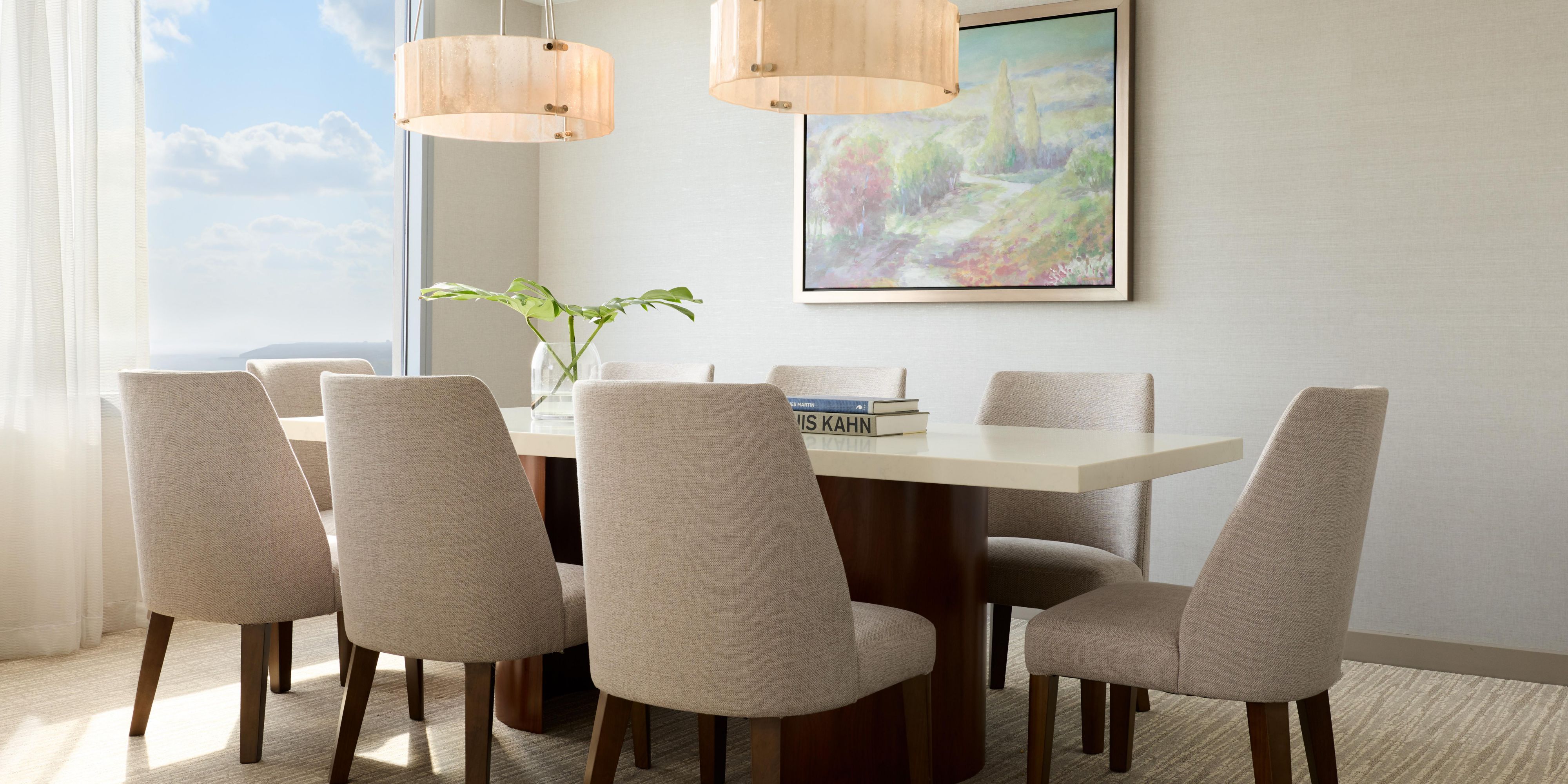 Dining room with table, chairs, and large windows.