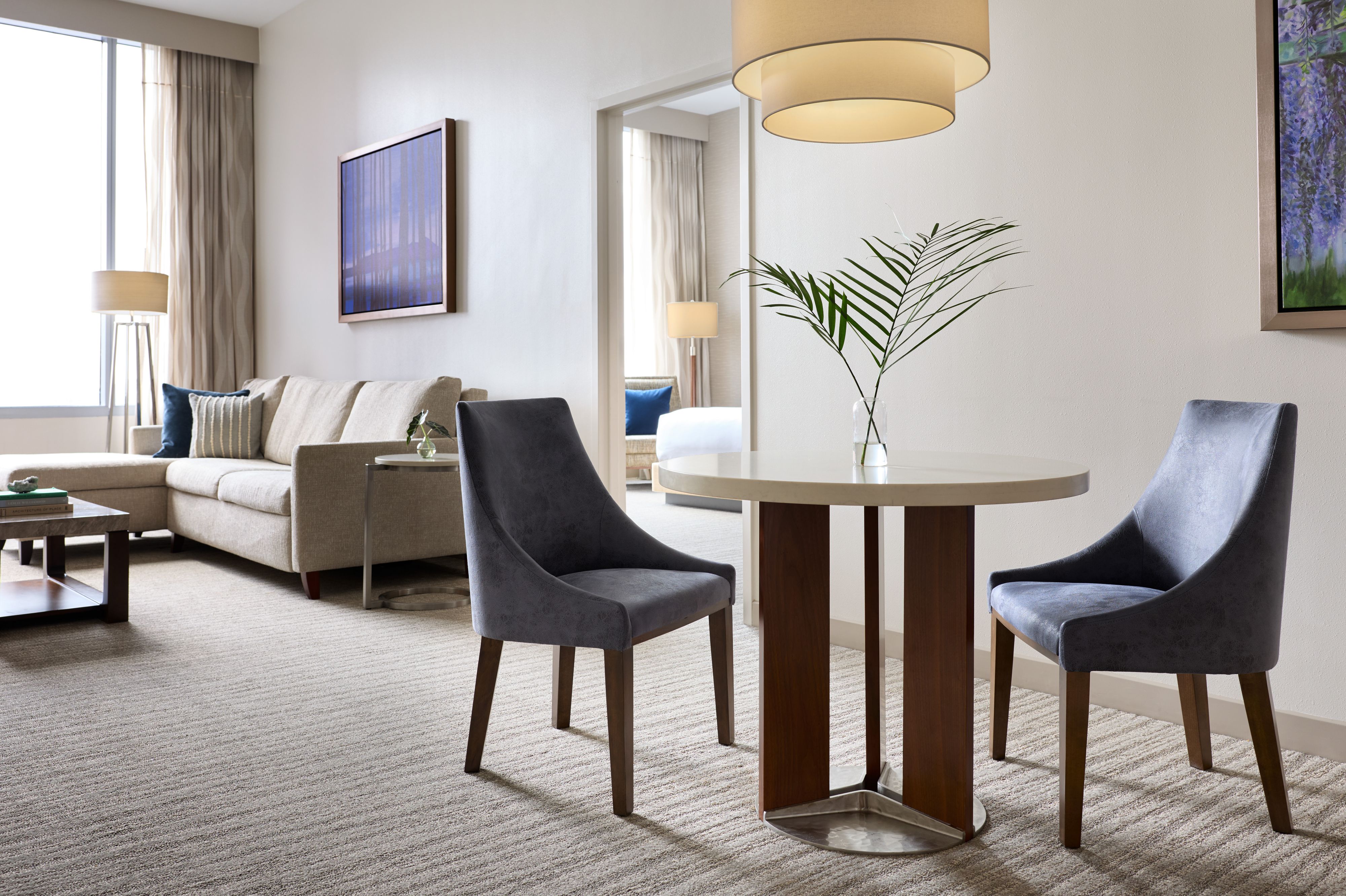 Hotel suite dining area with chairs, sofa, and window seating,