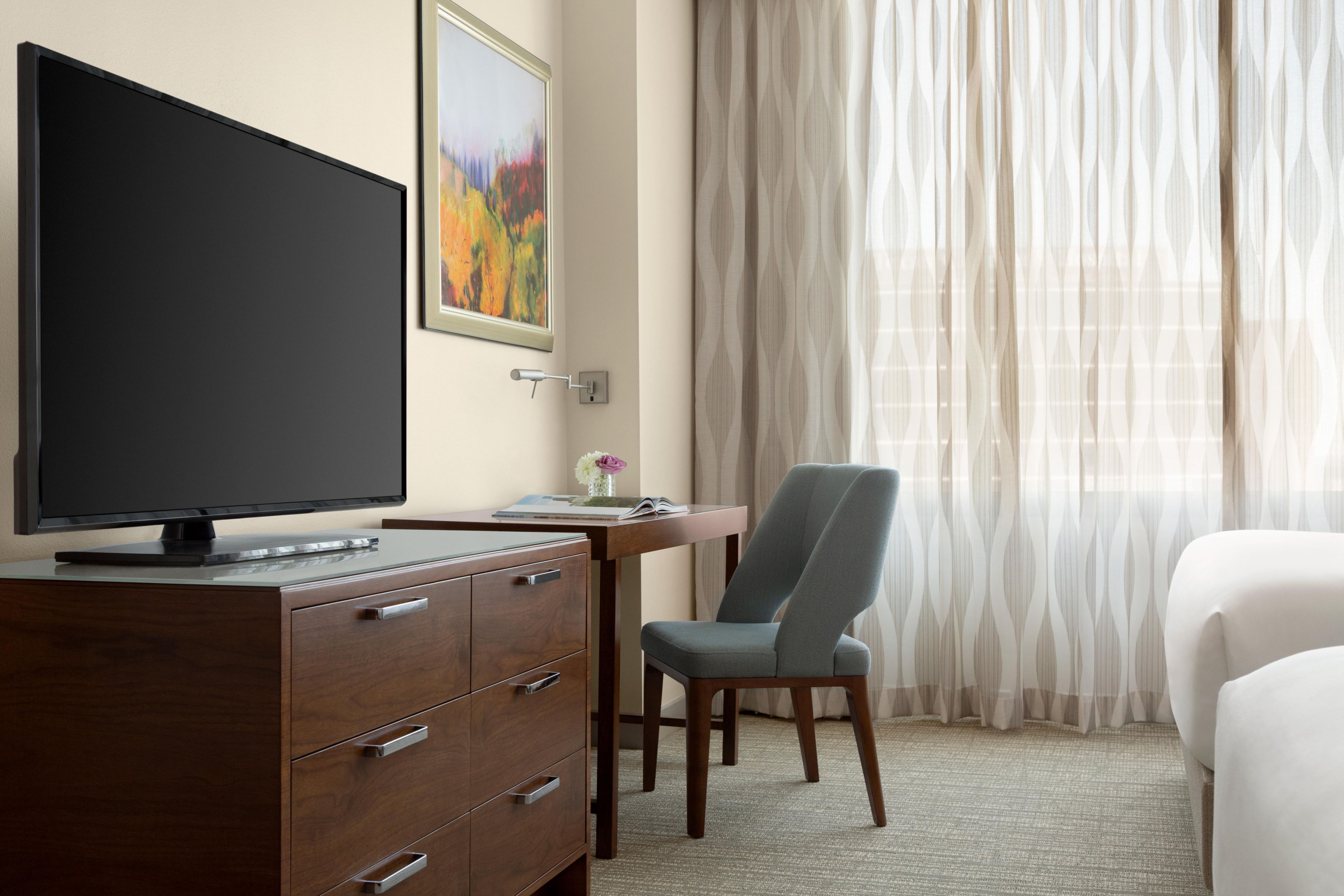 IC Houston guestroom featuring entertainment tv area with table and blue chair
