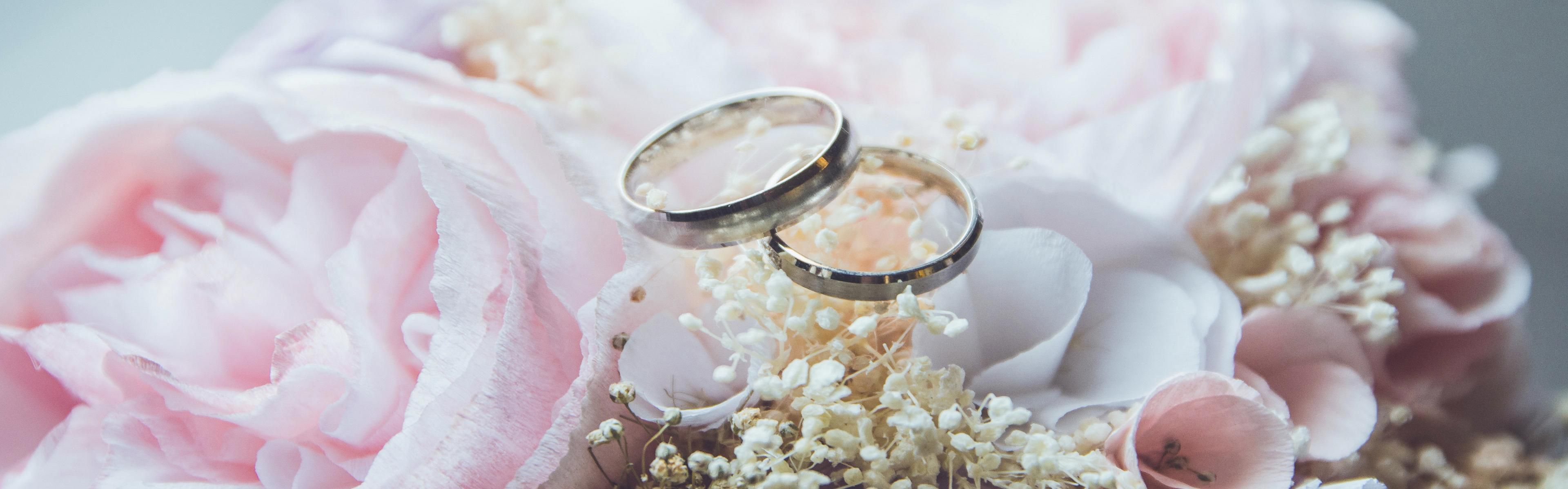 Bride posing in white gown holding pink flowers