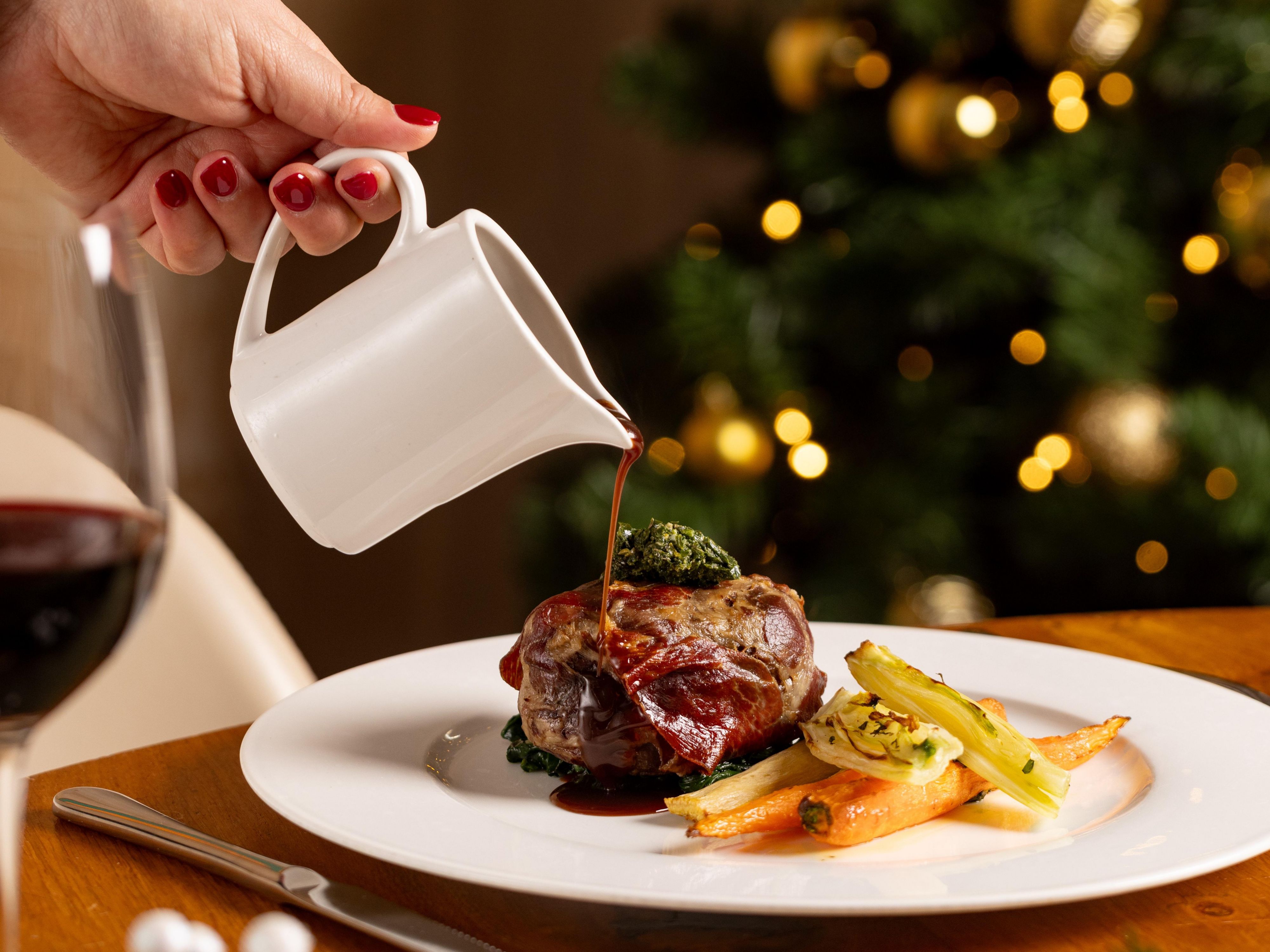 Mother and daughter sitting next to Christmas tree
