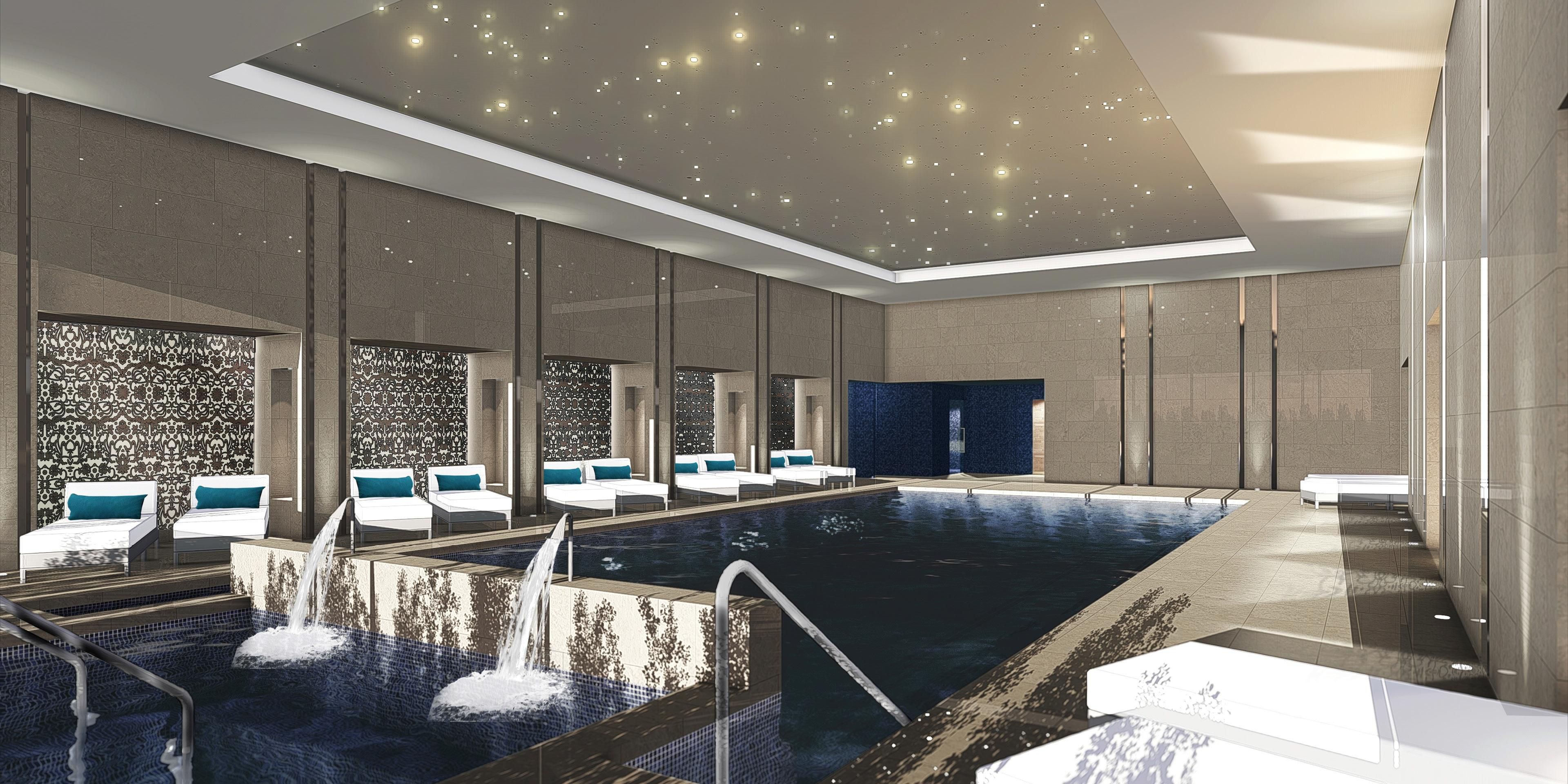 Serene indoor pool surrounded by elegant relaxation spaces.