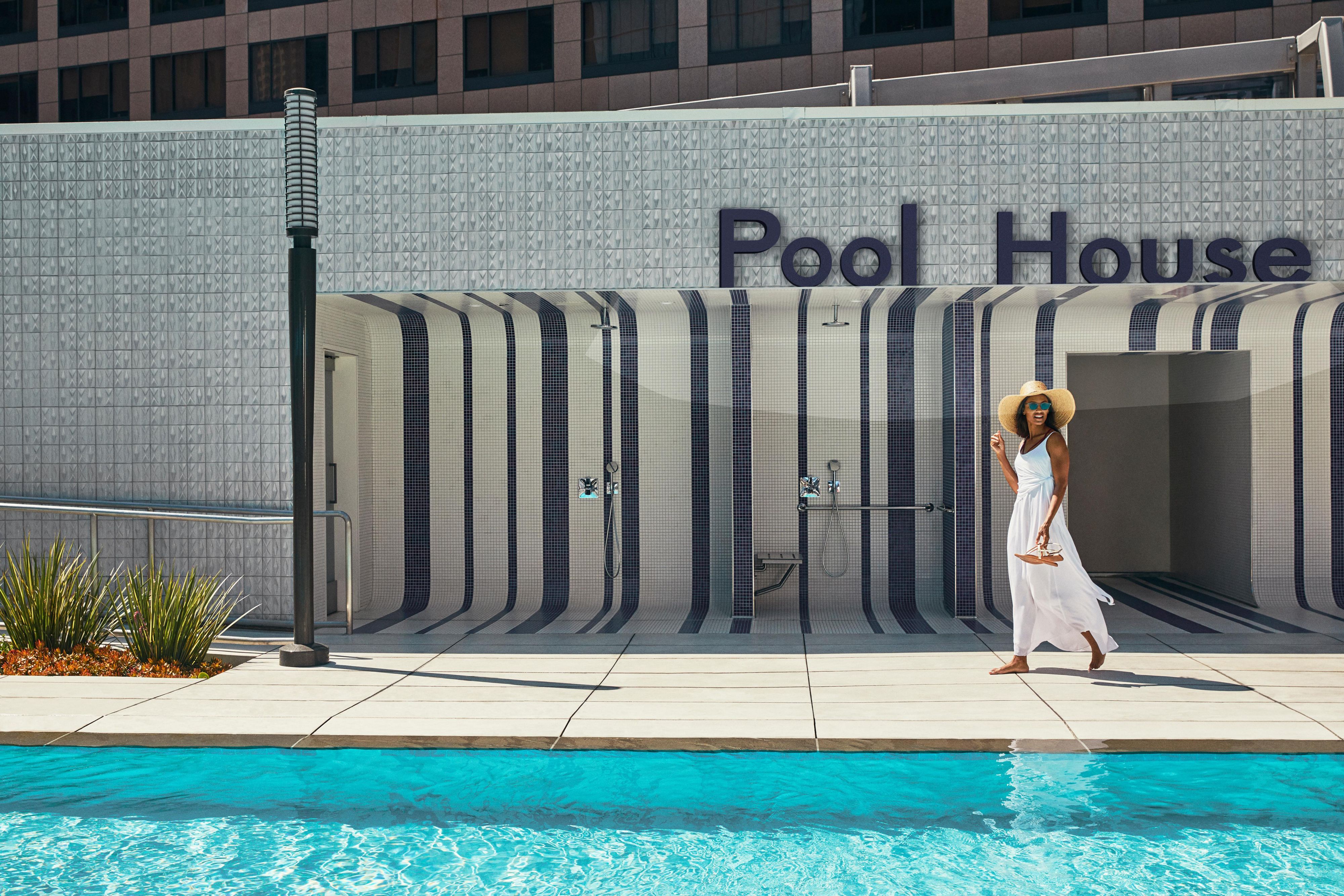 Guest walking in front of Pool House at InterContinental Los Angeles Downtown's rooftop pool.