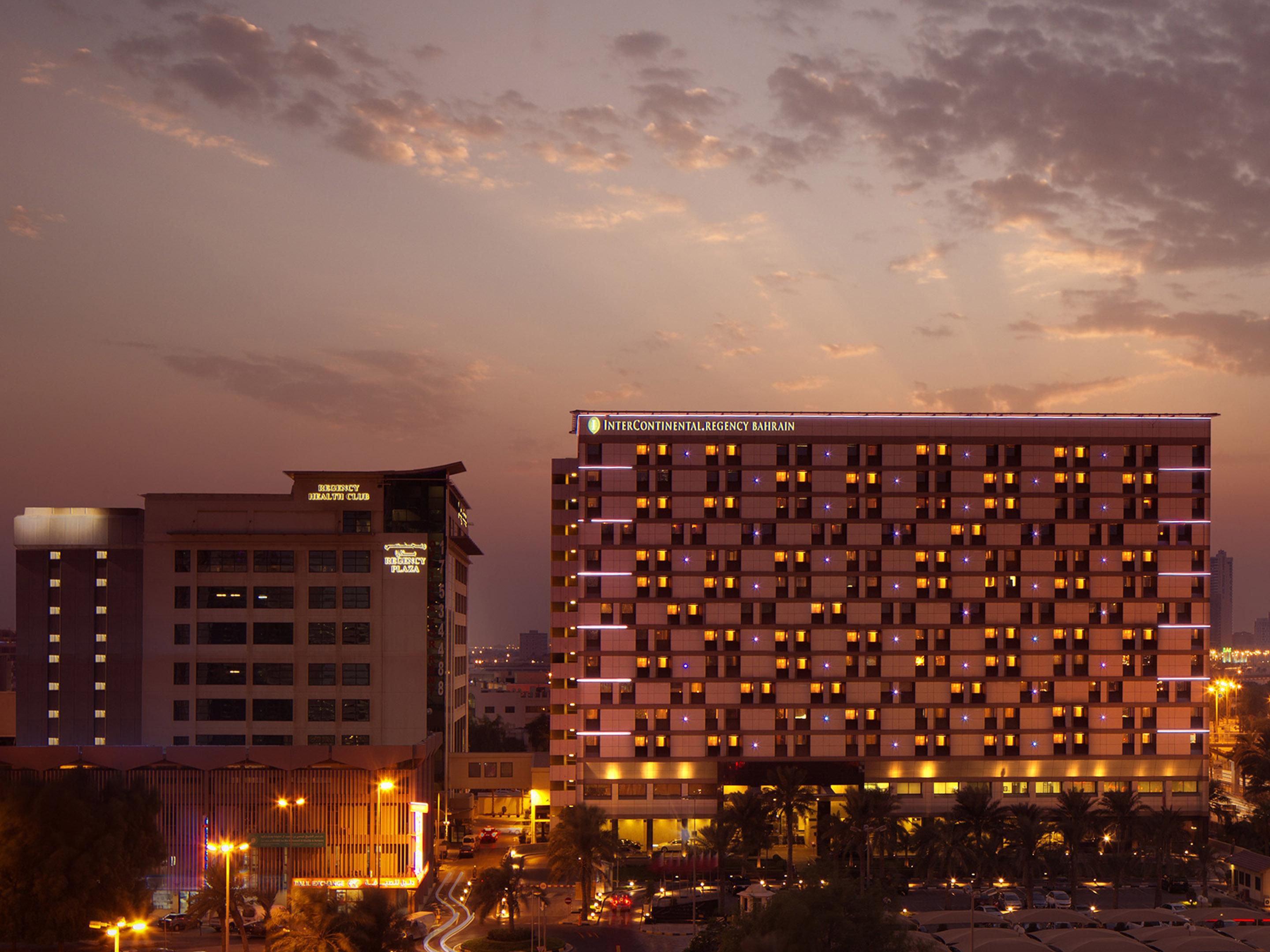Exterior of the hotel in twilight against city skyline