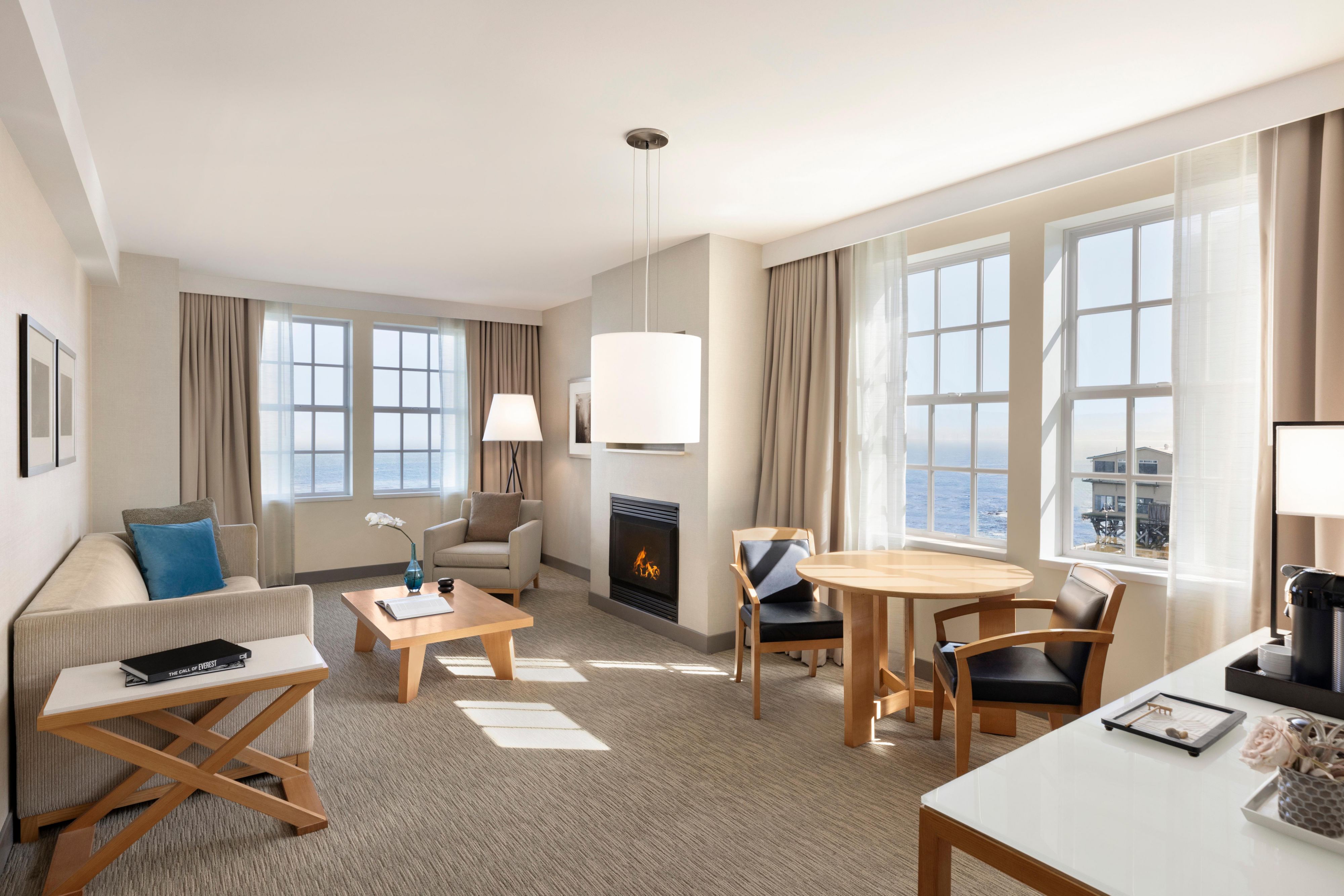 Spacious suite living room with ocean views and a fireplace.