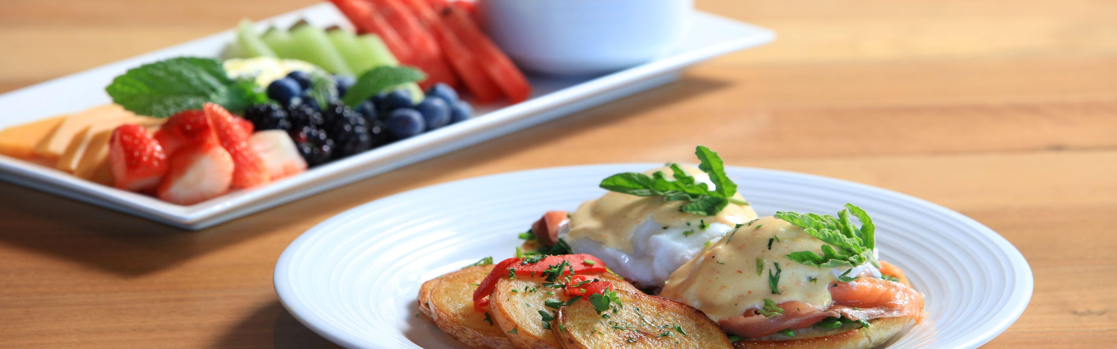 Eggs Benedict. Seasonal fruit, granola & low fat Greek yogurt