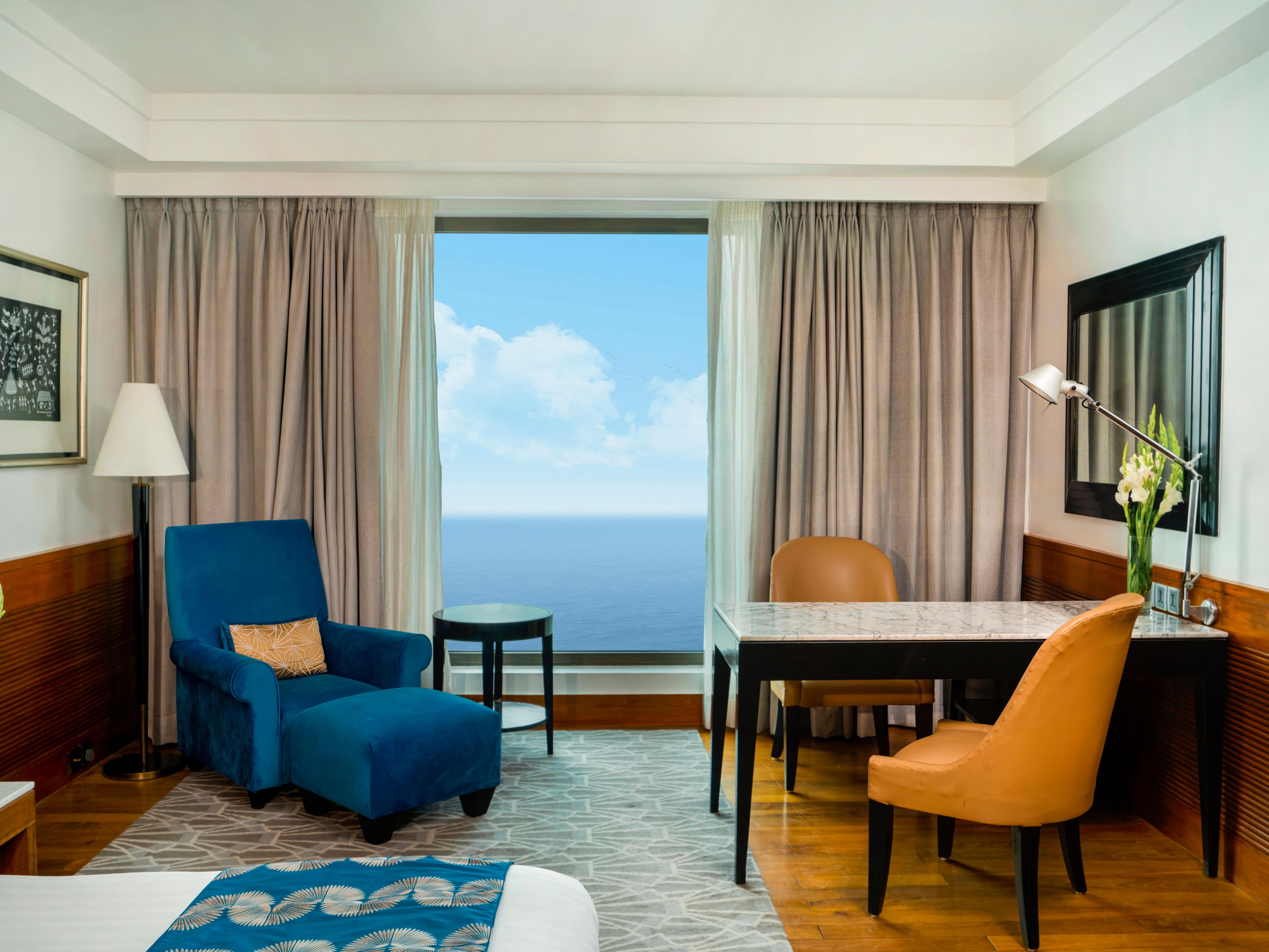 A comfortable armchair and marble top desk overlooking the sea