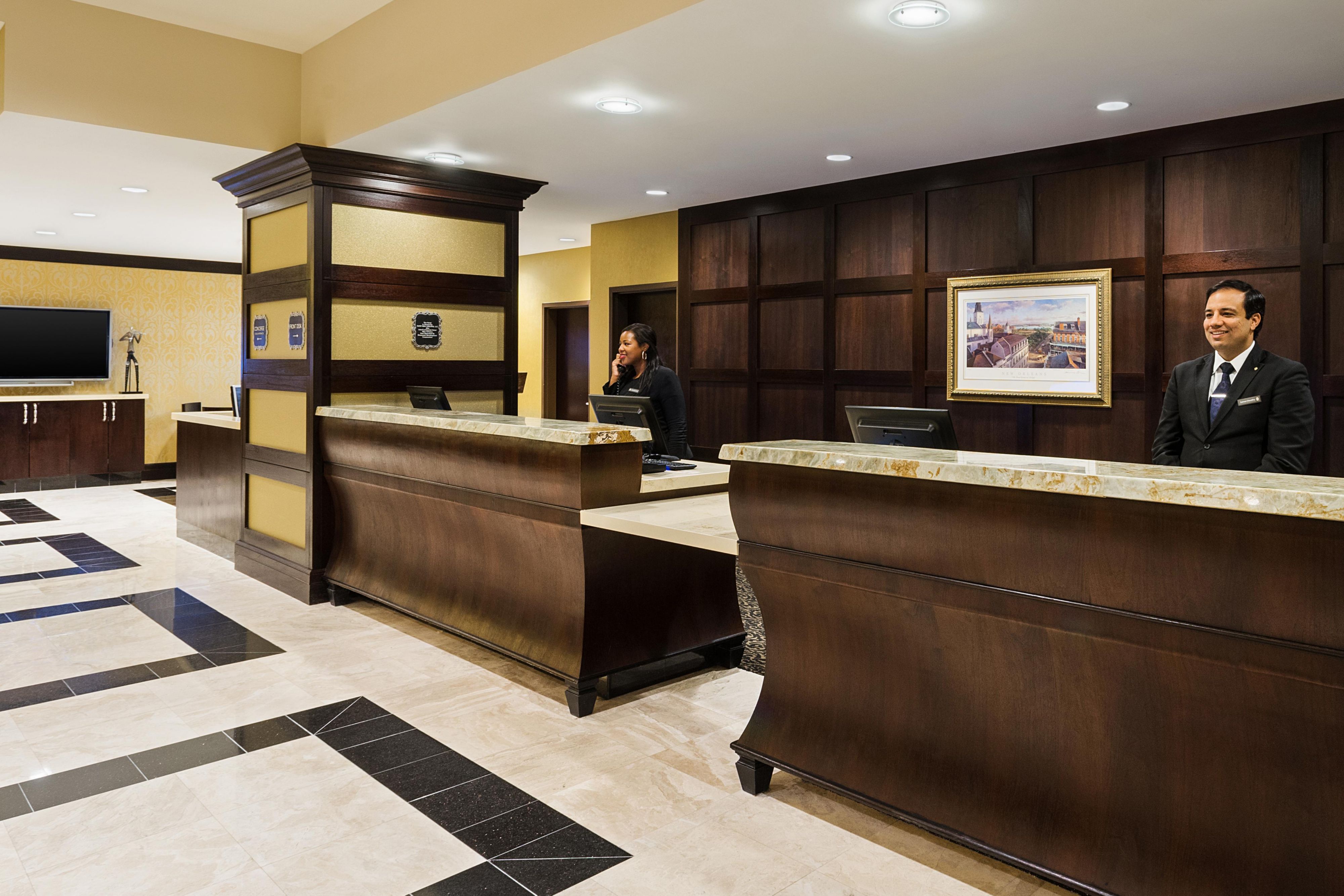 Hotel front desk with staff at reception counters in a modern lobby