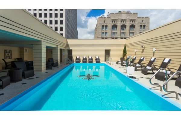 Rooftop pool with lounge chairs and downtown city views.