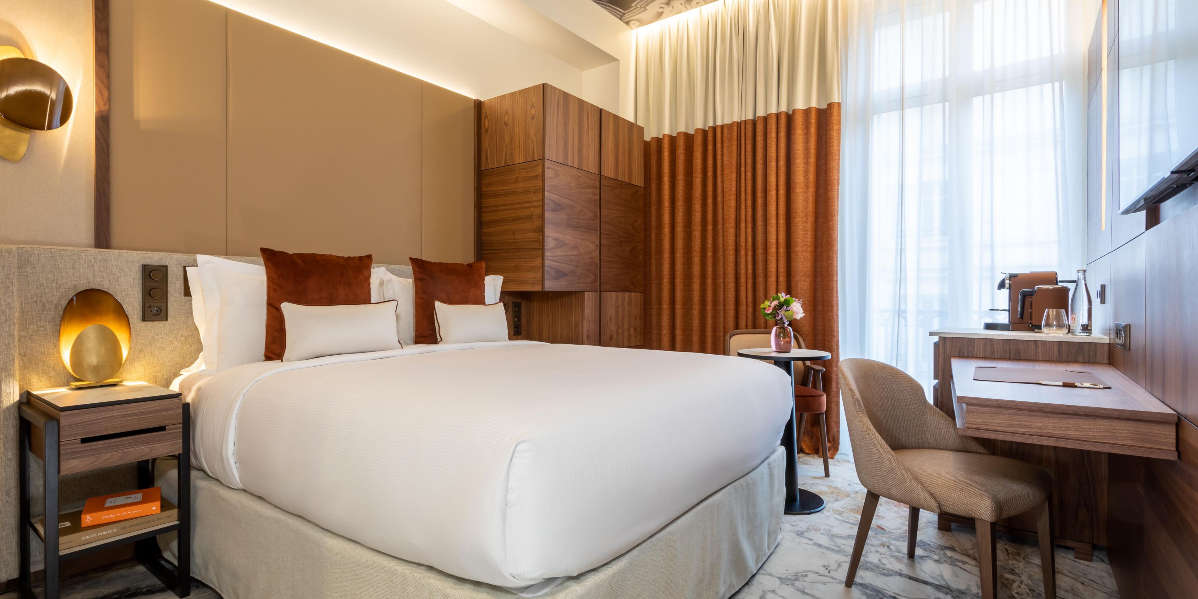 Kamar nyaman dengan tempat tidur Queen, meja, dan kursi berlengan