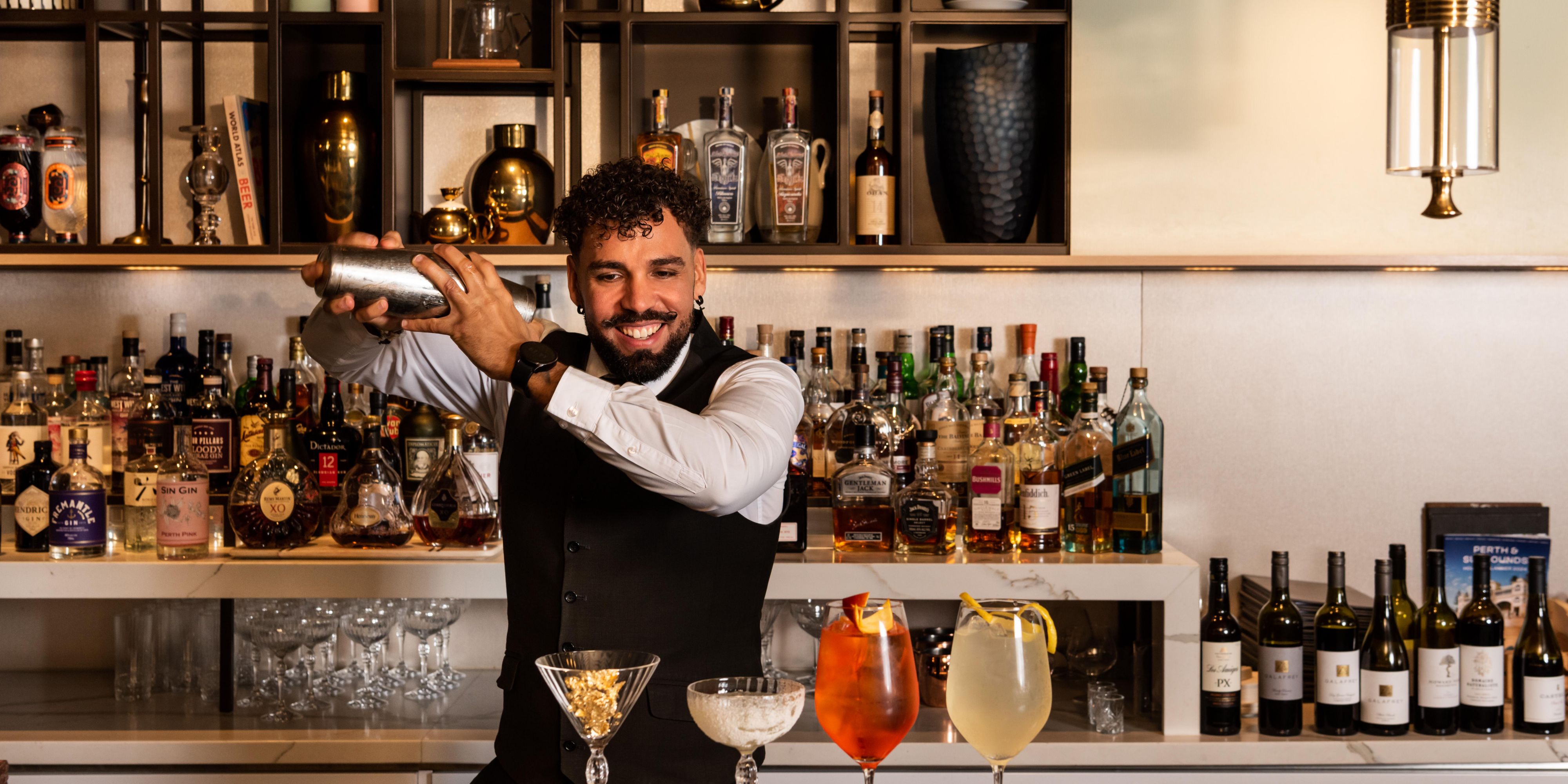 Bartender smiling while mixing a drink.