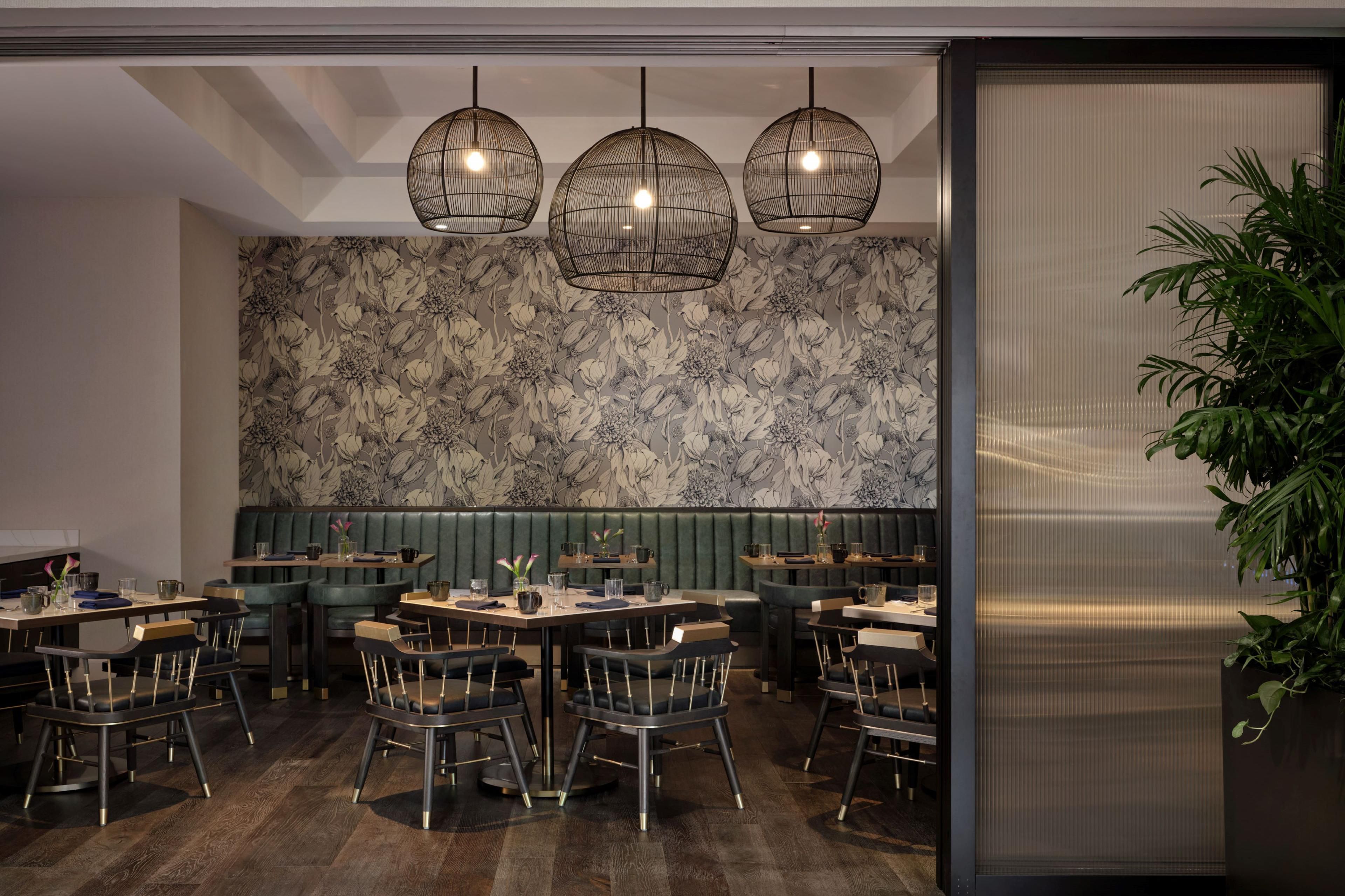 Contemporary cocktail bar with wraparound seating and illuminated architectural lighting.