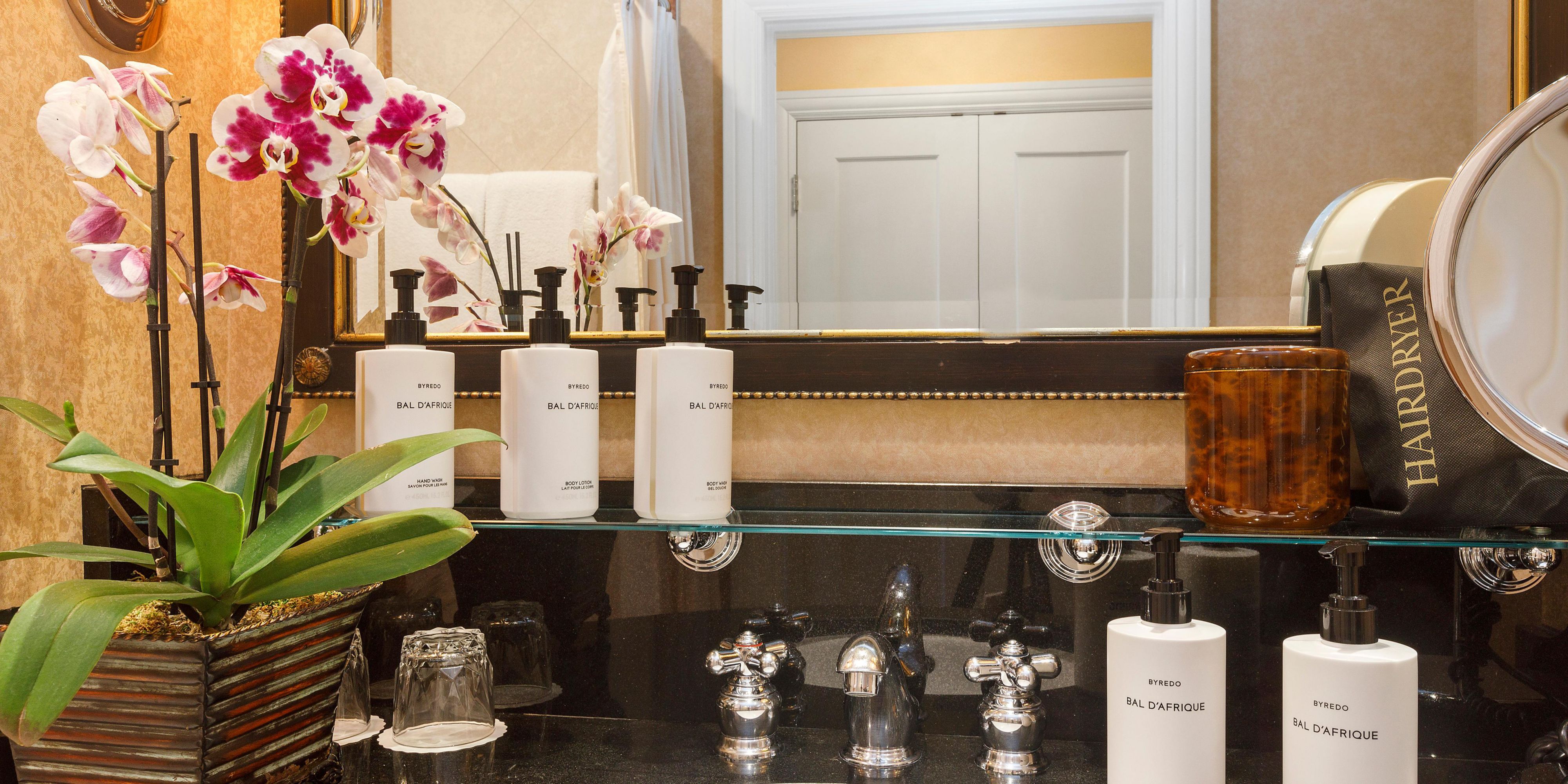 Classic marbled bathrooms with Byredo® bath amenities.