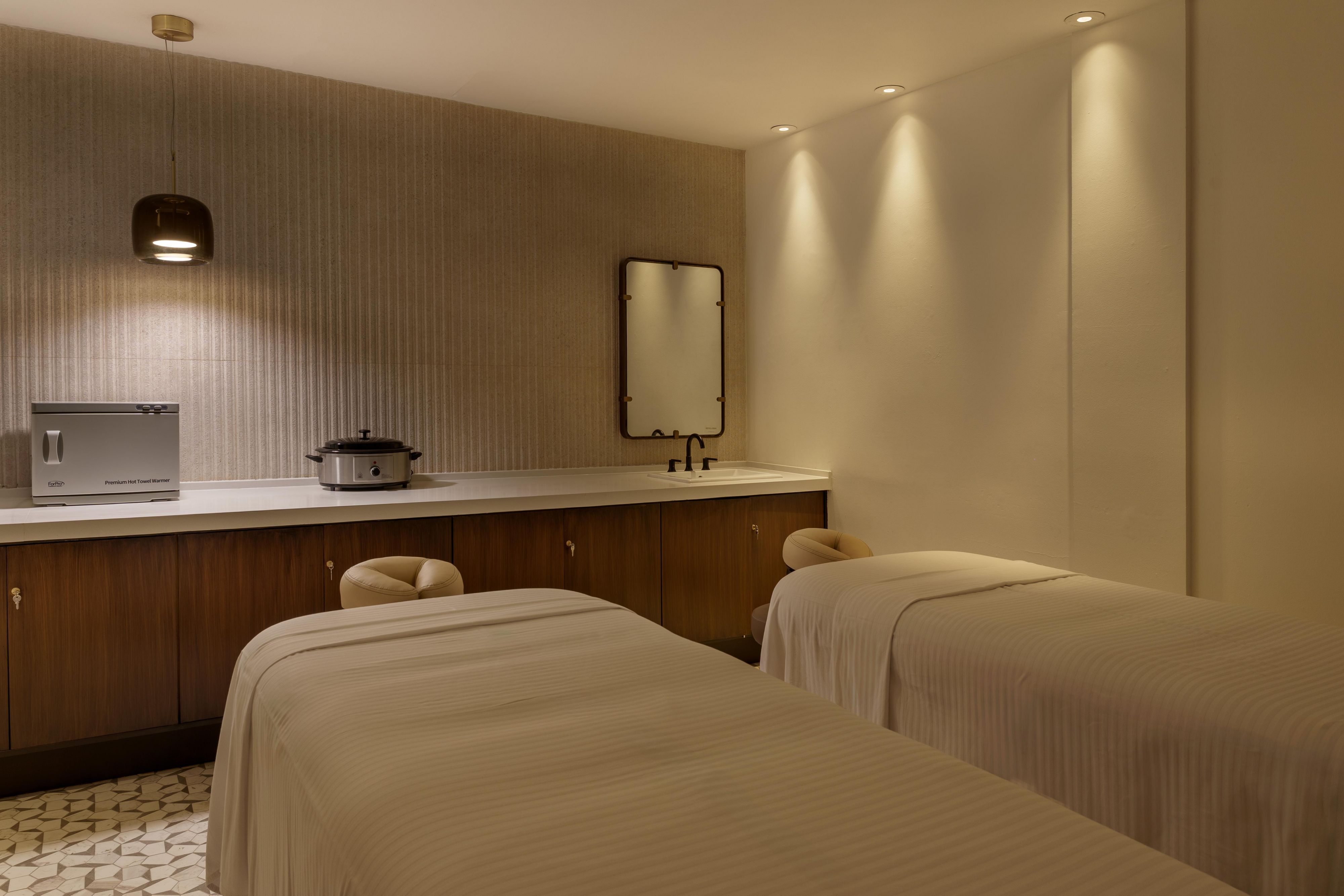 Spa treatment room with massage beds and soft lighting