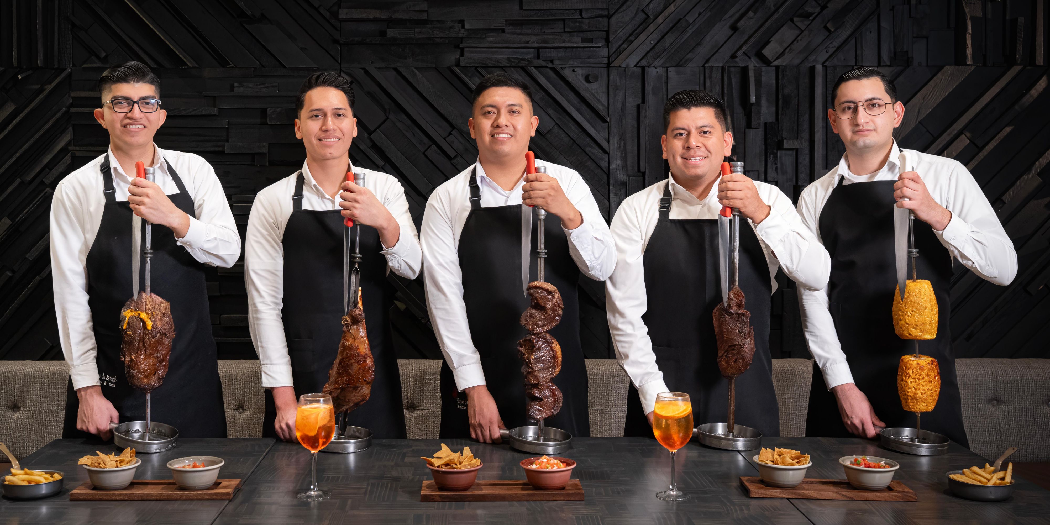 line of chefs holding steak skewers