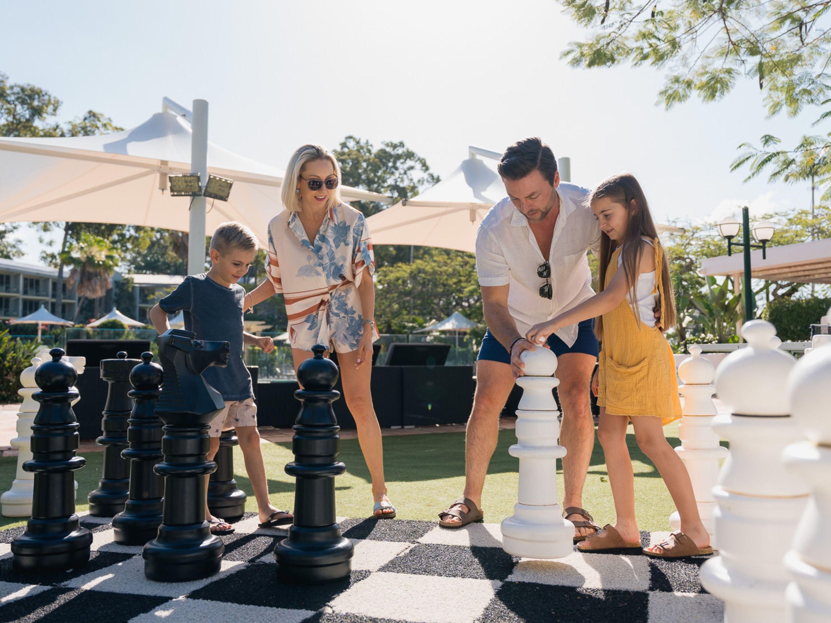 Family playing giant chess in the resort grounds
