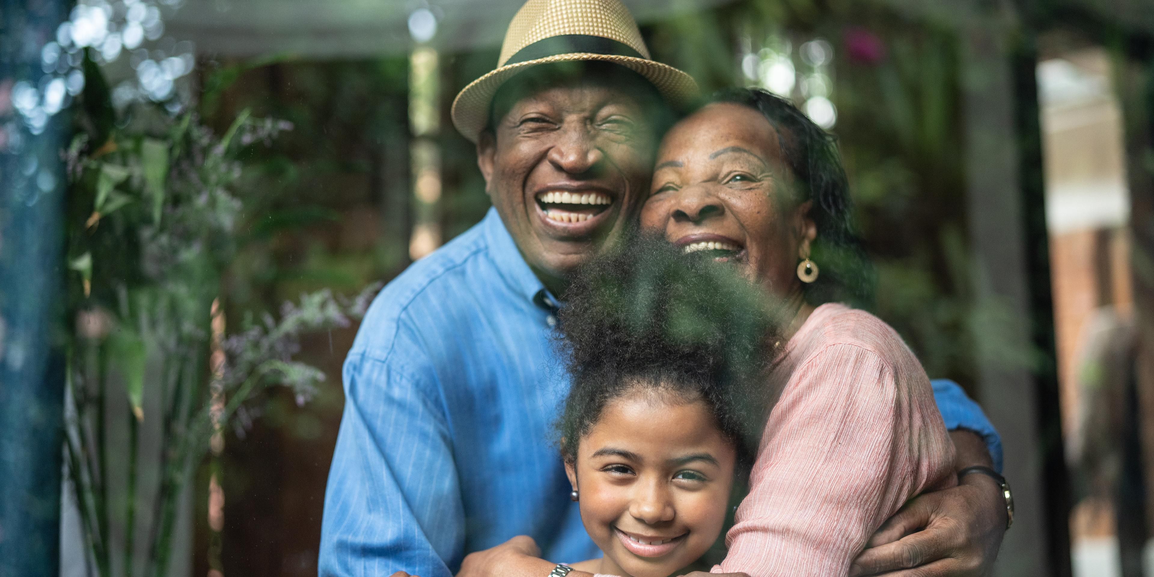 Older couple hugging child