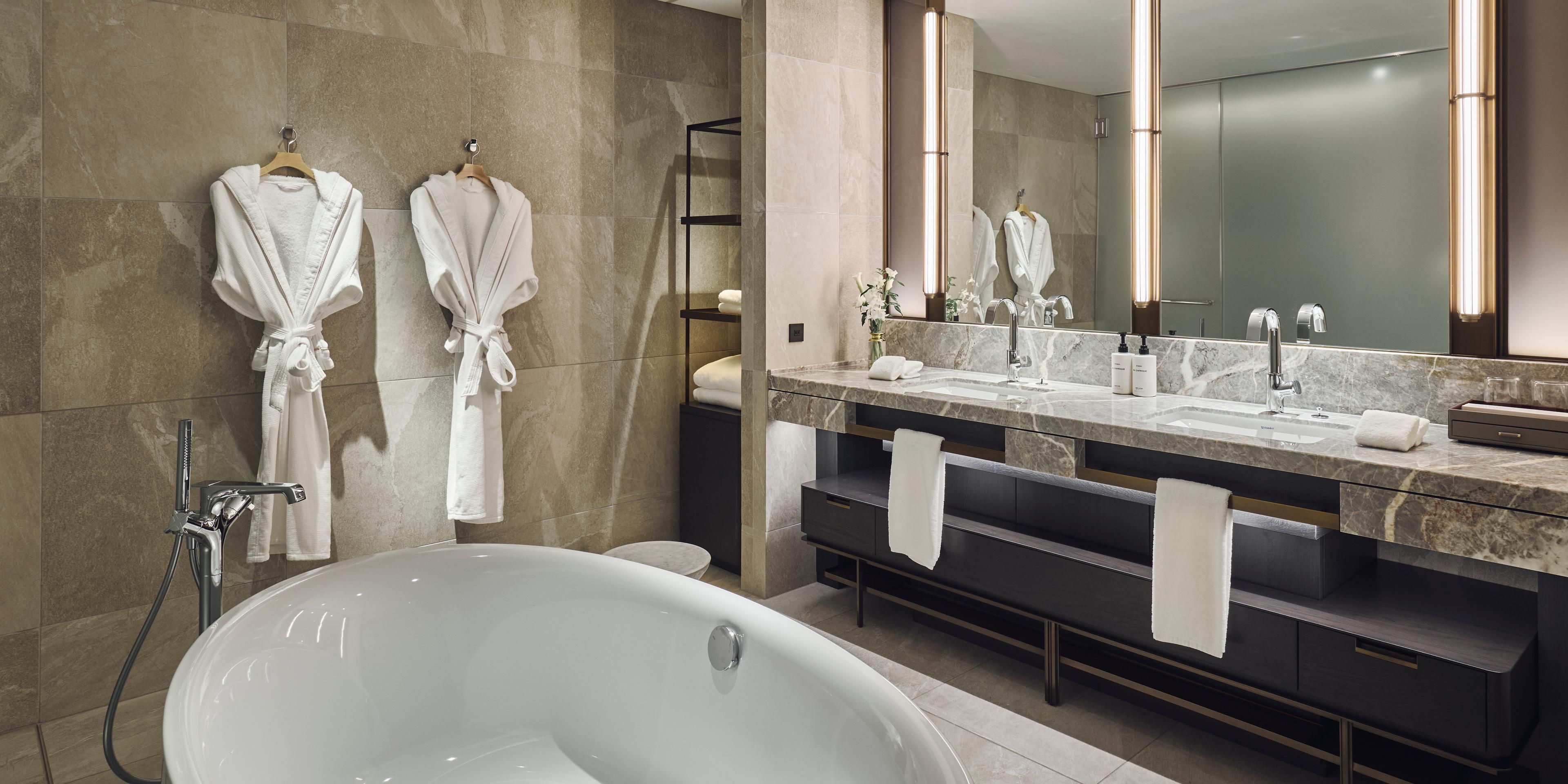 Spacious bathroom with dual vanity sinks and a separate bathtub 