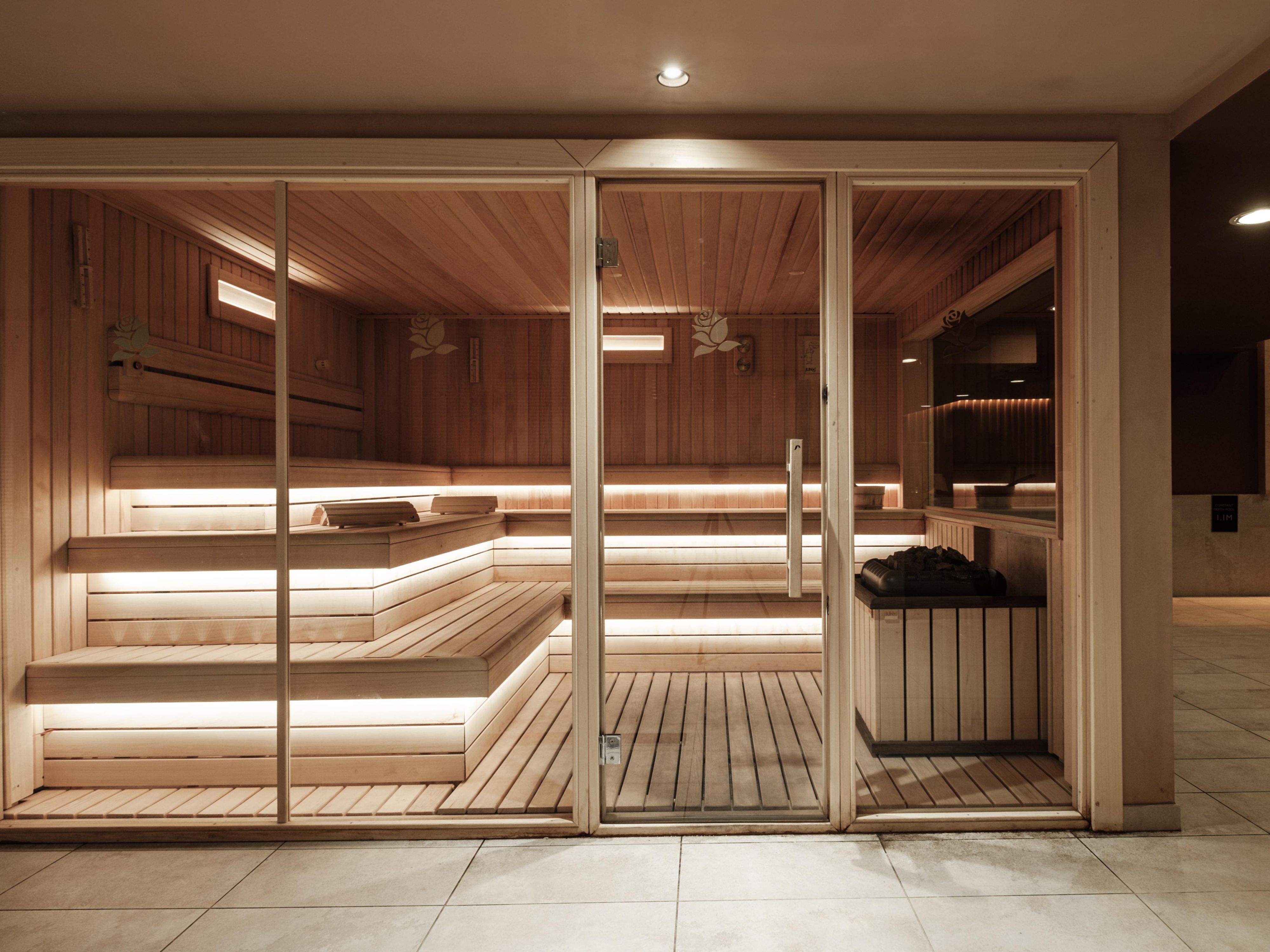 Modern wooden sauna with tiered seating and soft ambient lighting