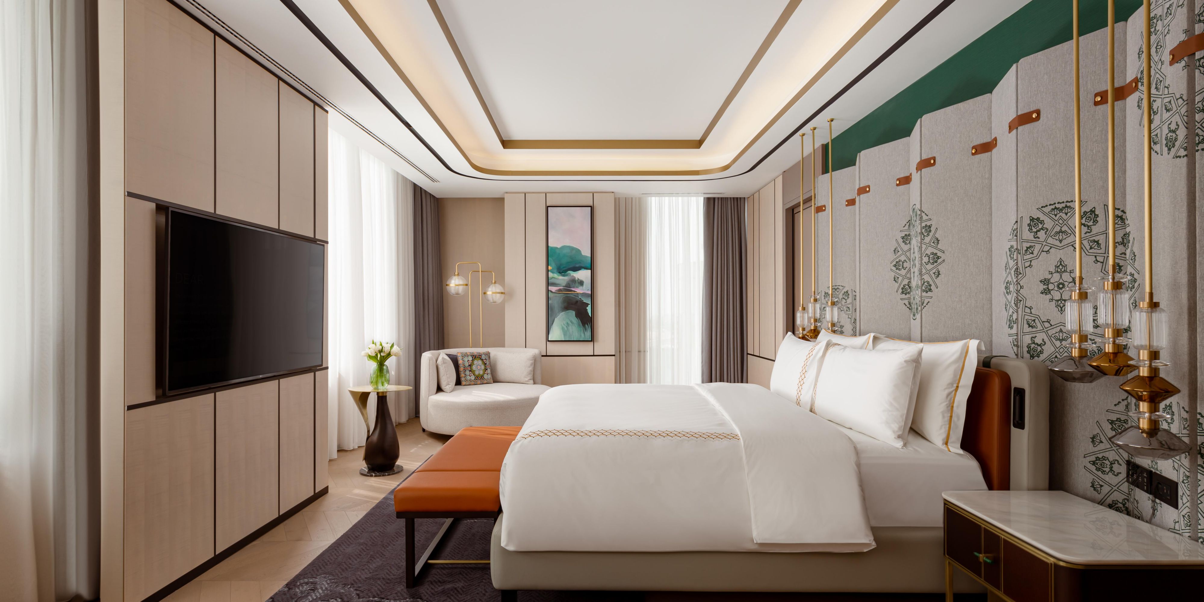 The bedroom in Presidential Suite with a TV and corner sofa.