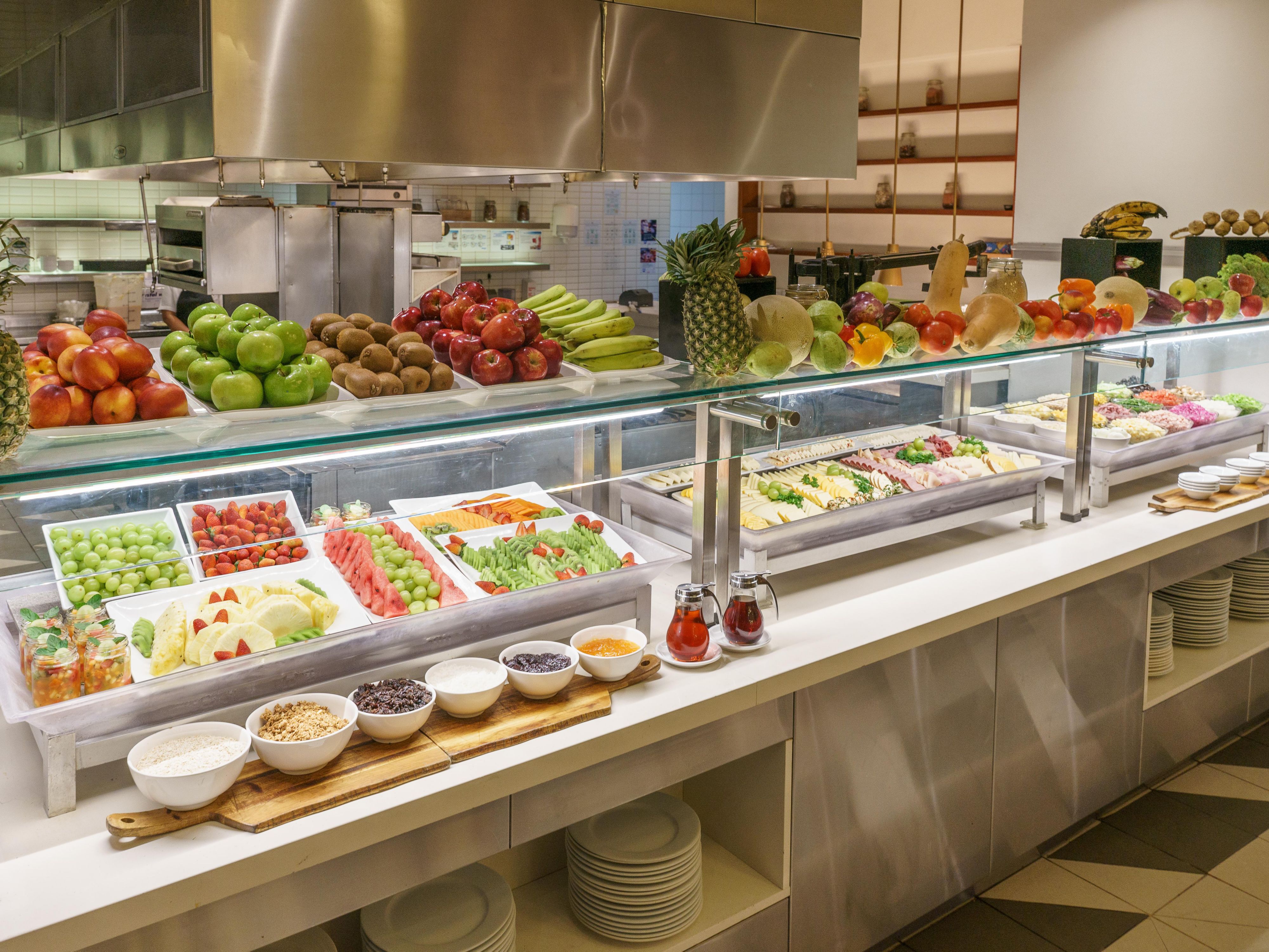 Breakfast buffet includes selections of fruits, ham, and cheese.