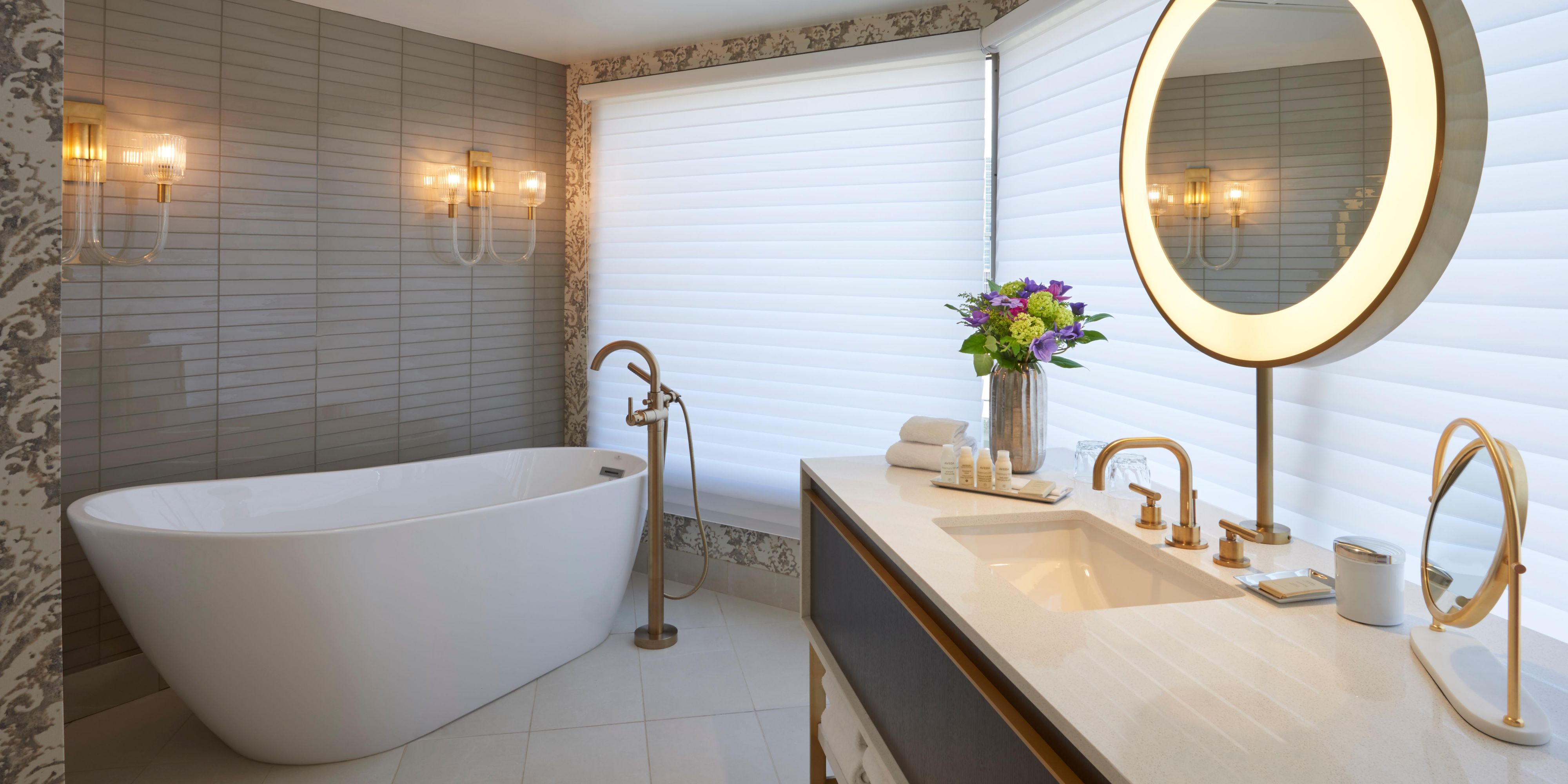 Spacious, marble-finished bathroom with separate bath and shower.