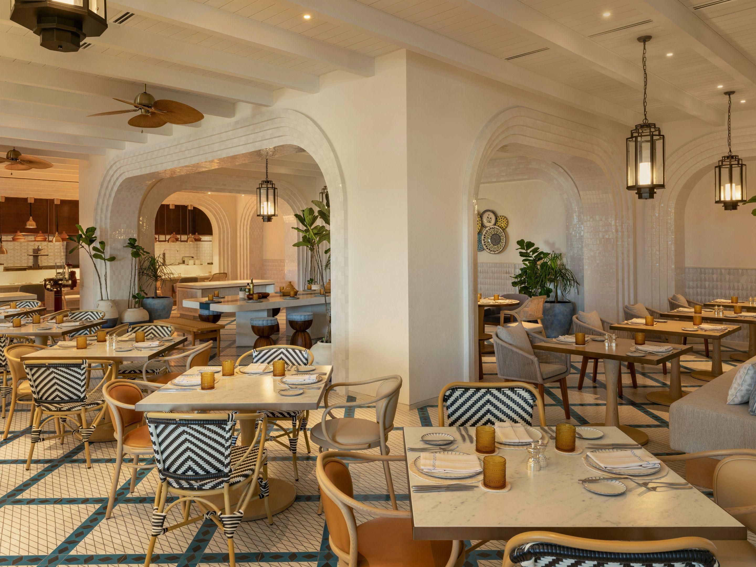 Puppy playing with champagne toy on hotel bed.