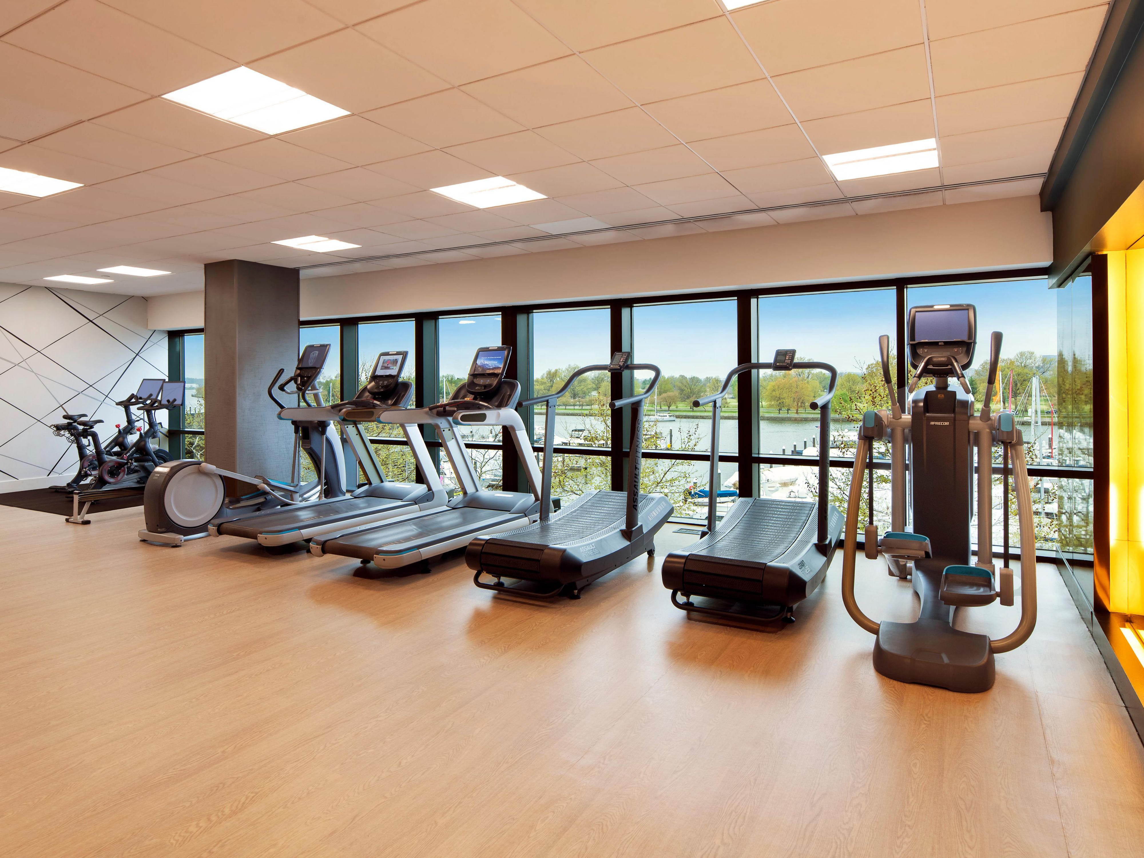 Fitness center with waterfront views and cardio equipment.