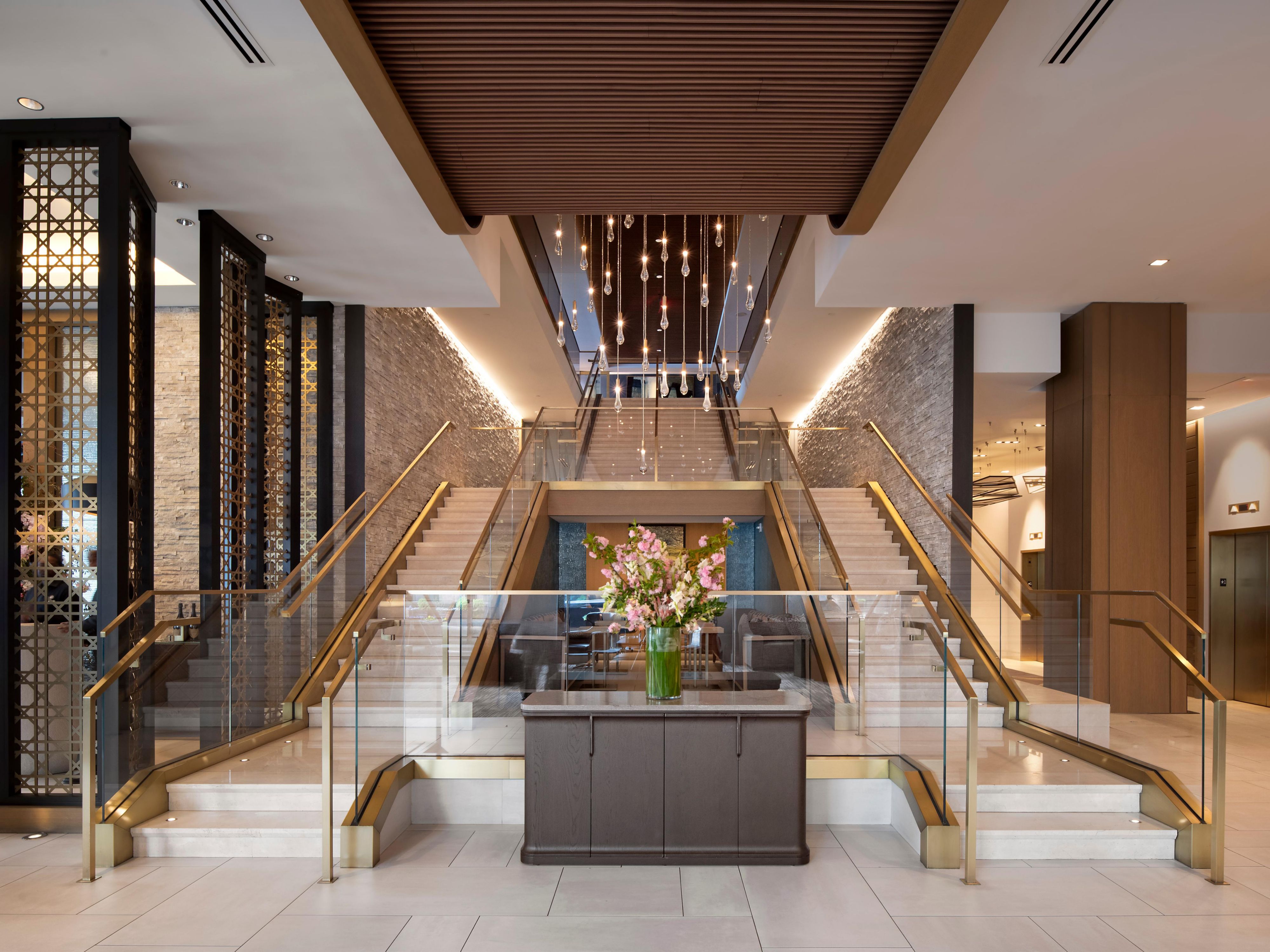 Grand lobby with sculptural lighting and sweeping staircase.