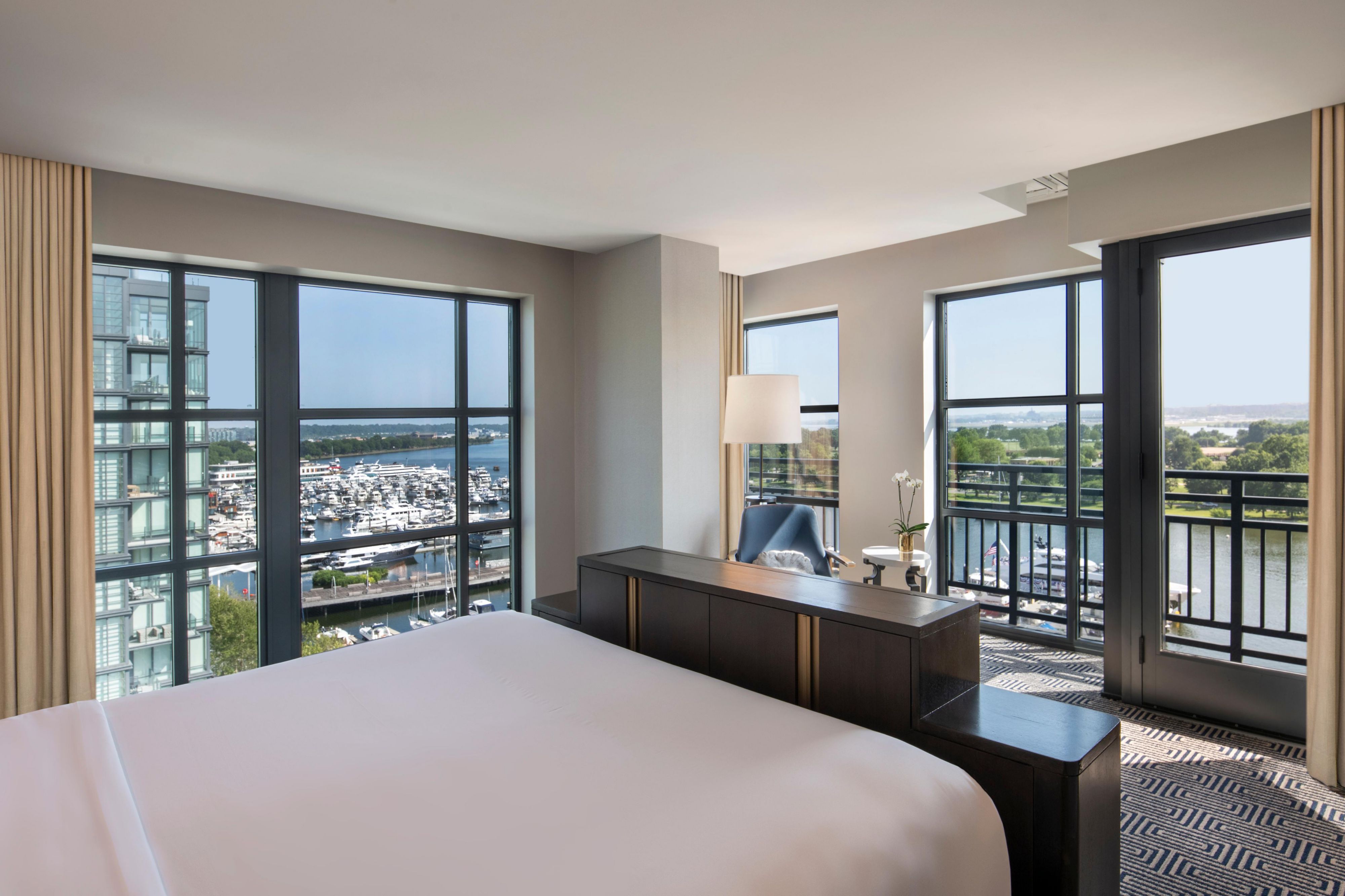 Corner king bedroom with gold accents and sweeping river views.
