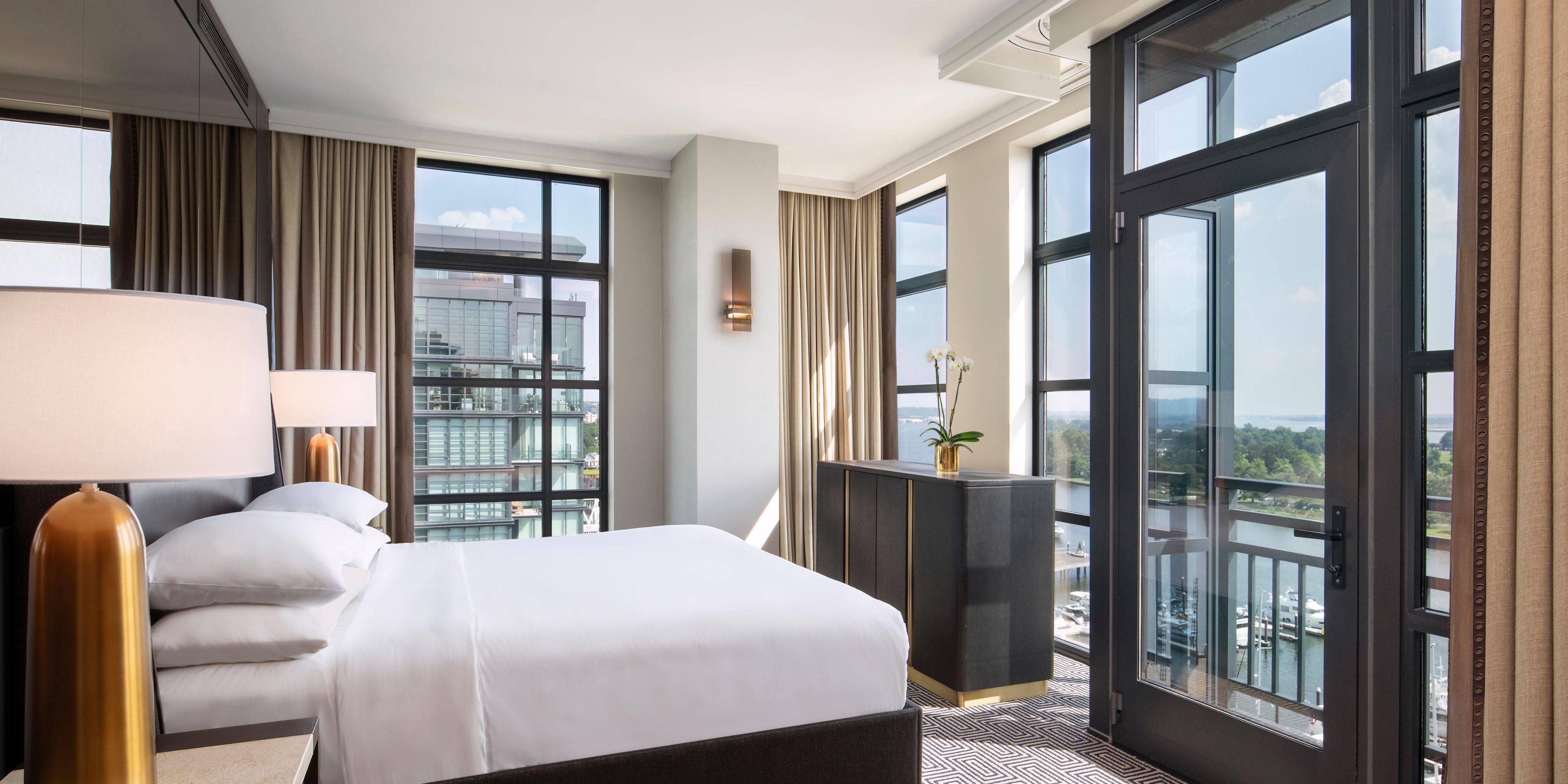 Corner king bedroom with gold-shaded lamp and marina views.