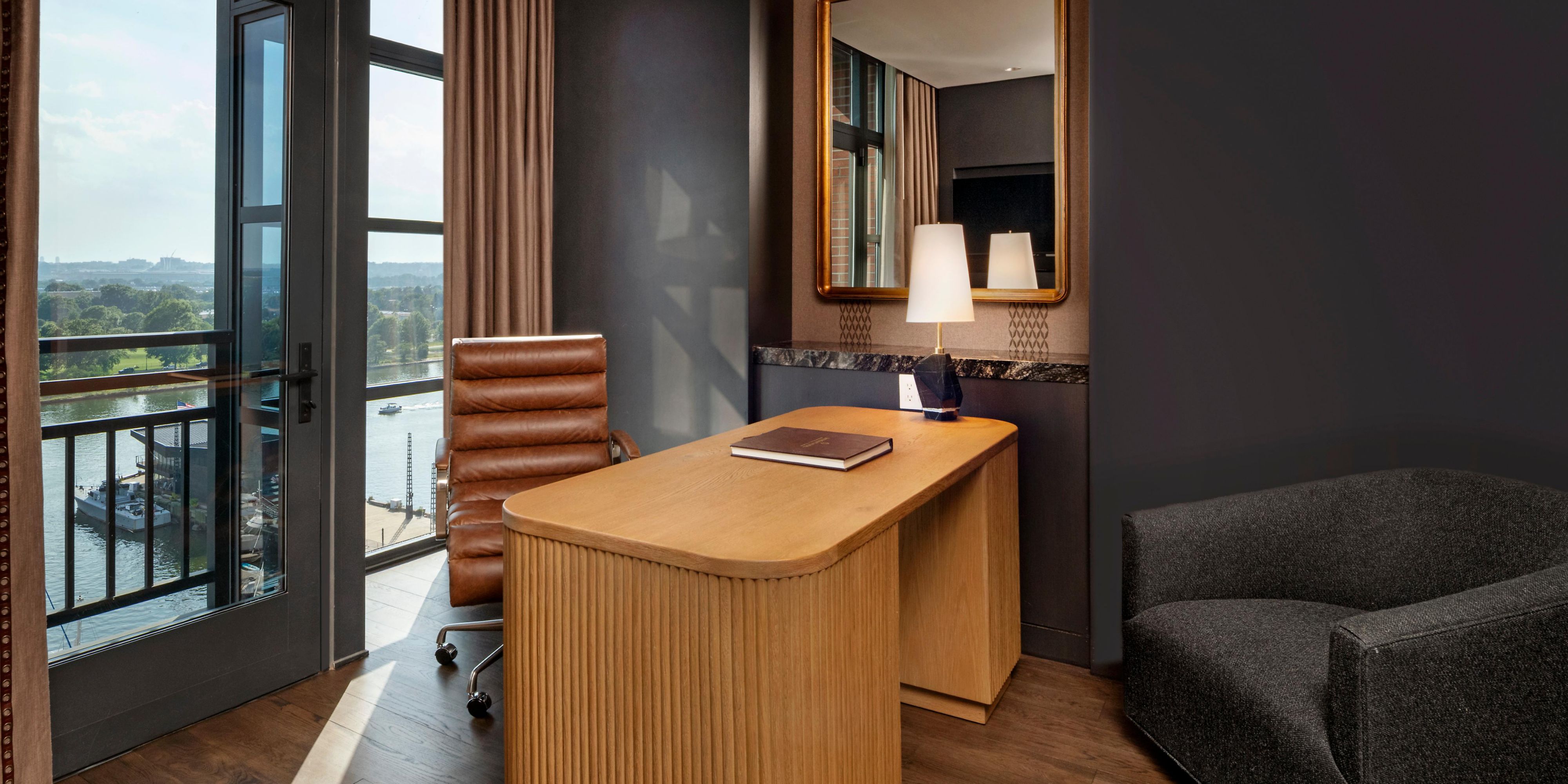 Refined workspace nook in a suite with desk and river views.