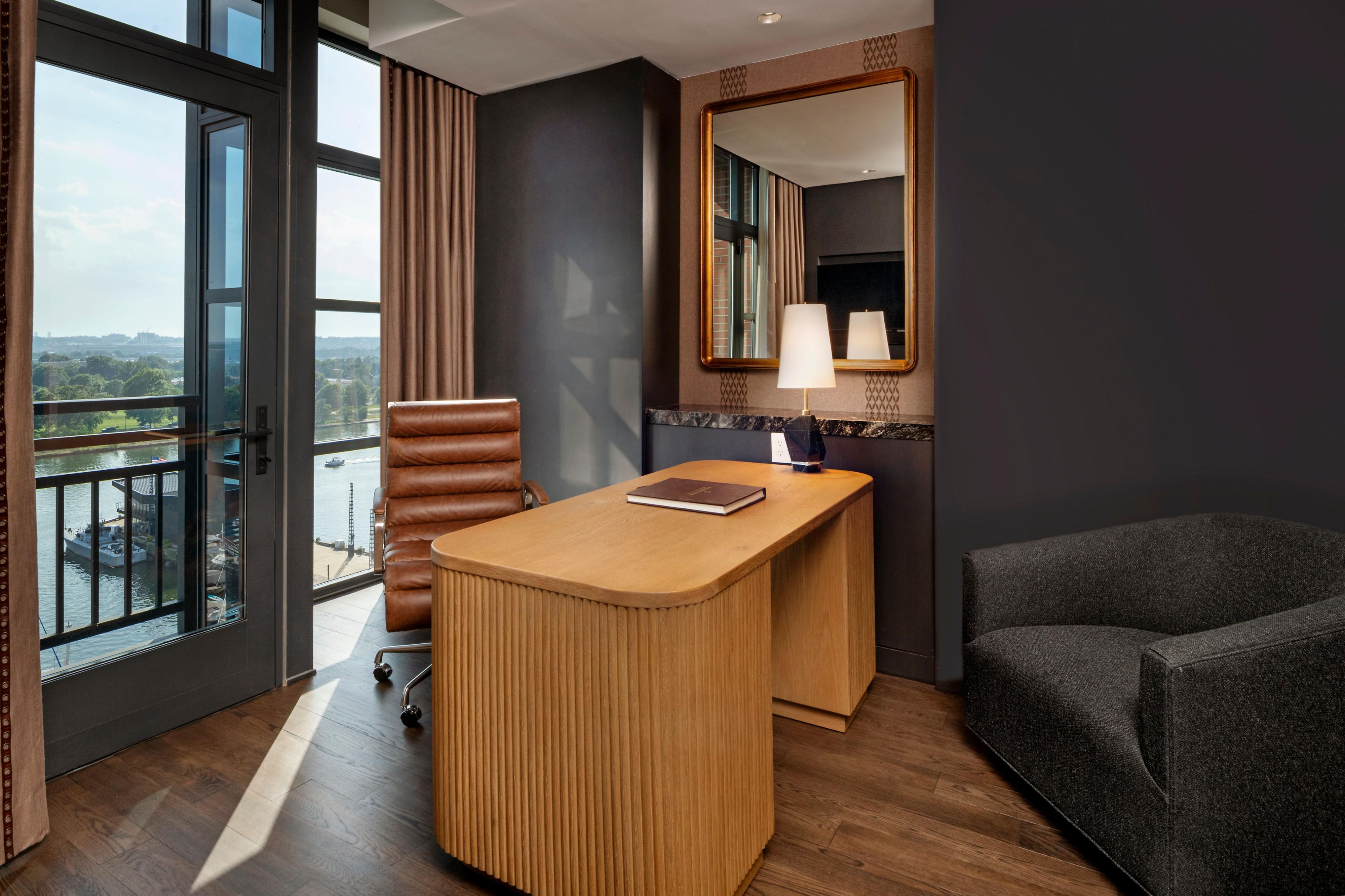 Refined workspace nook in a suite with desk and river views.