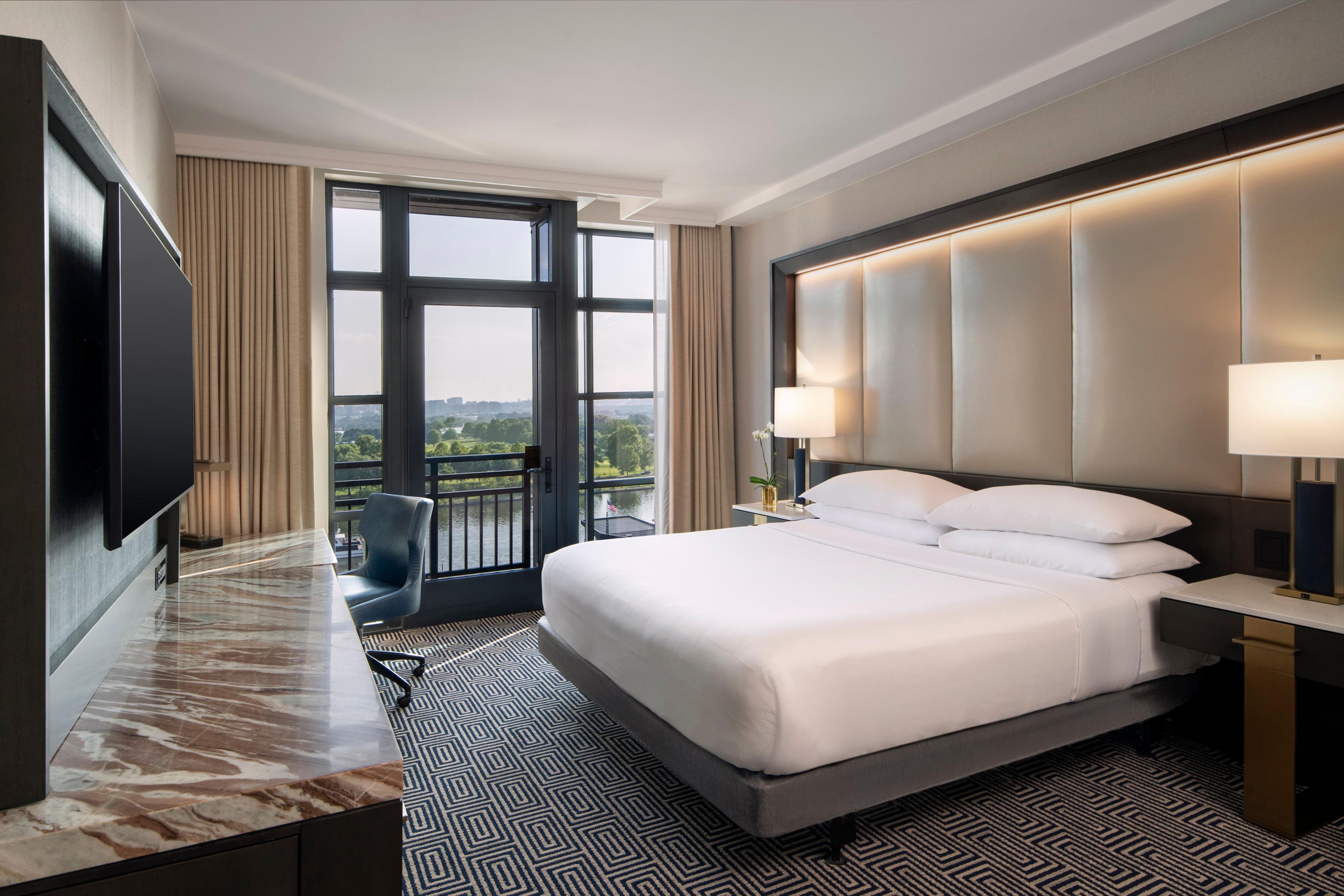 Executive riverview suite bedroom with king bed and wharf views.