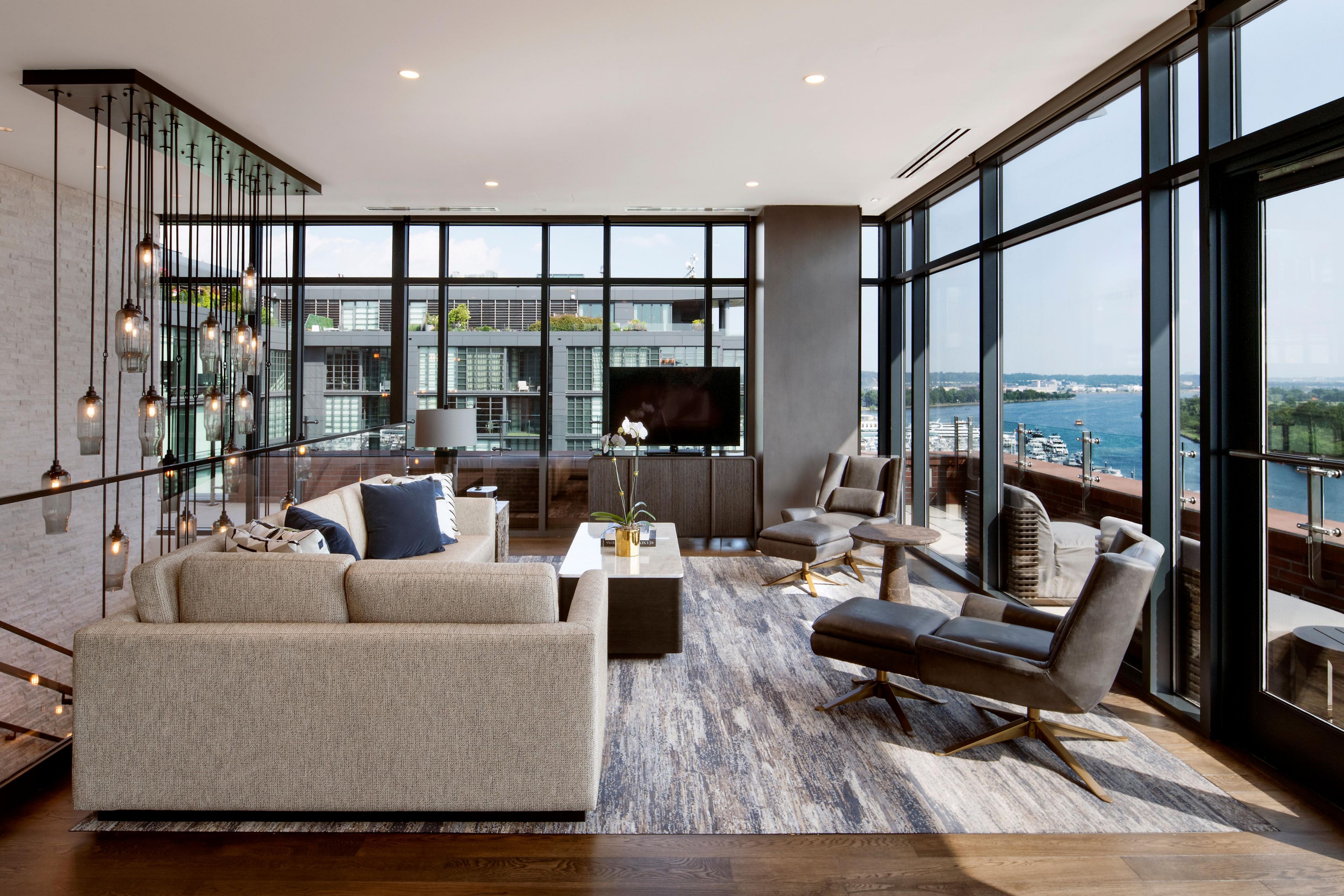 Suite living area with marble table and waterfront balcony.